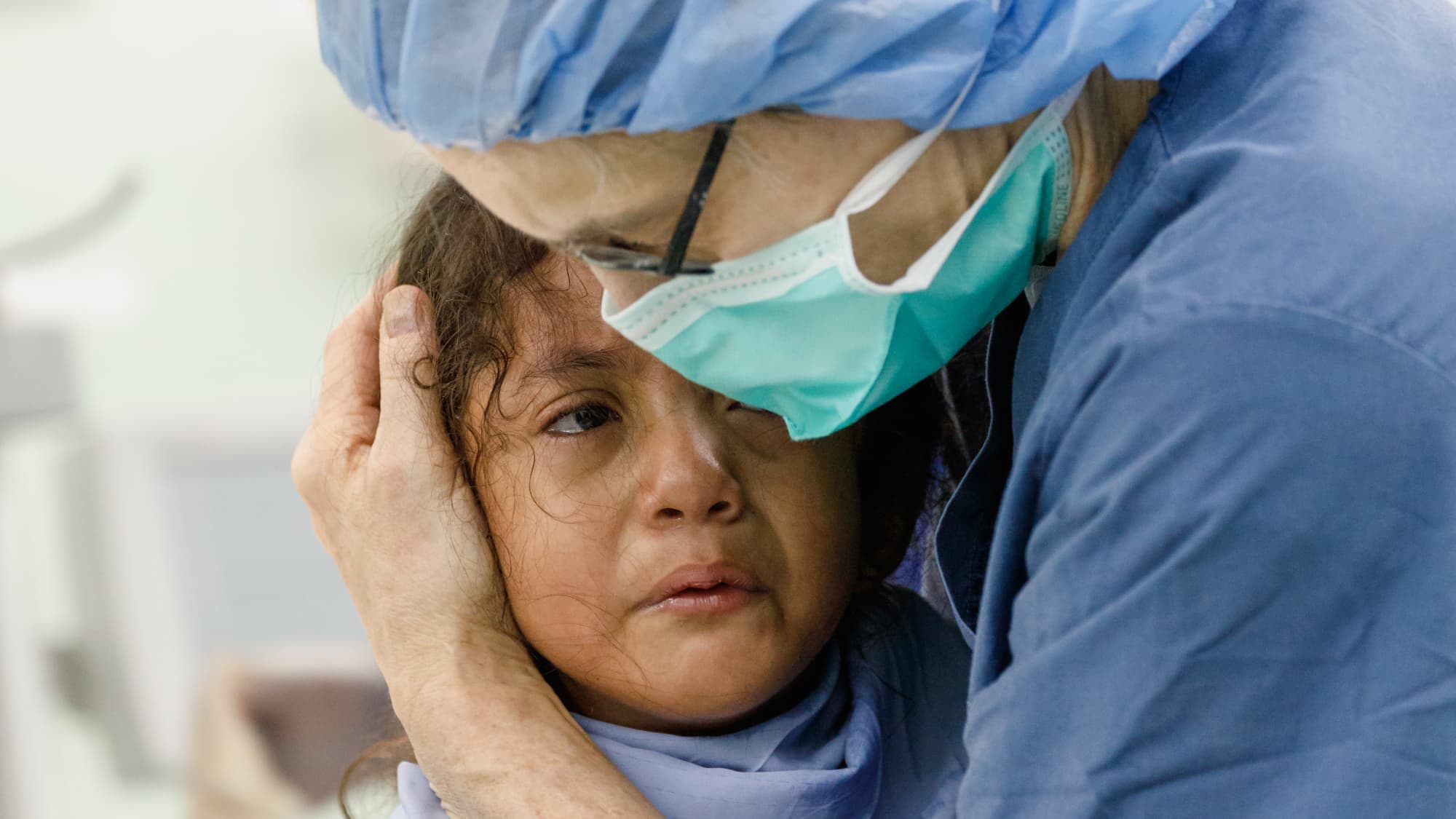 a nurse comforts a crying child.