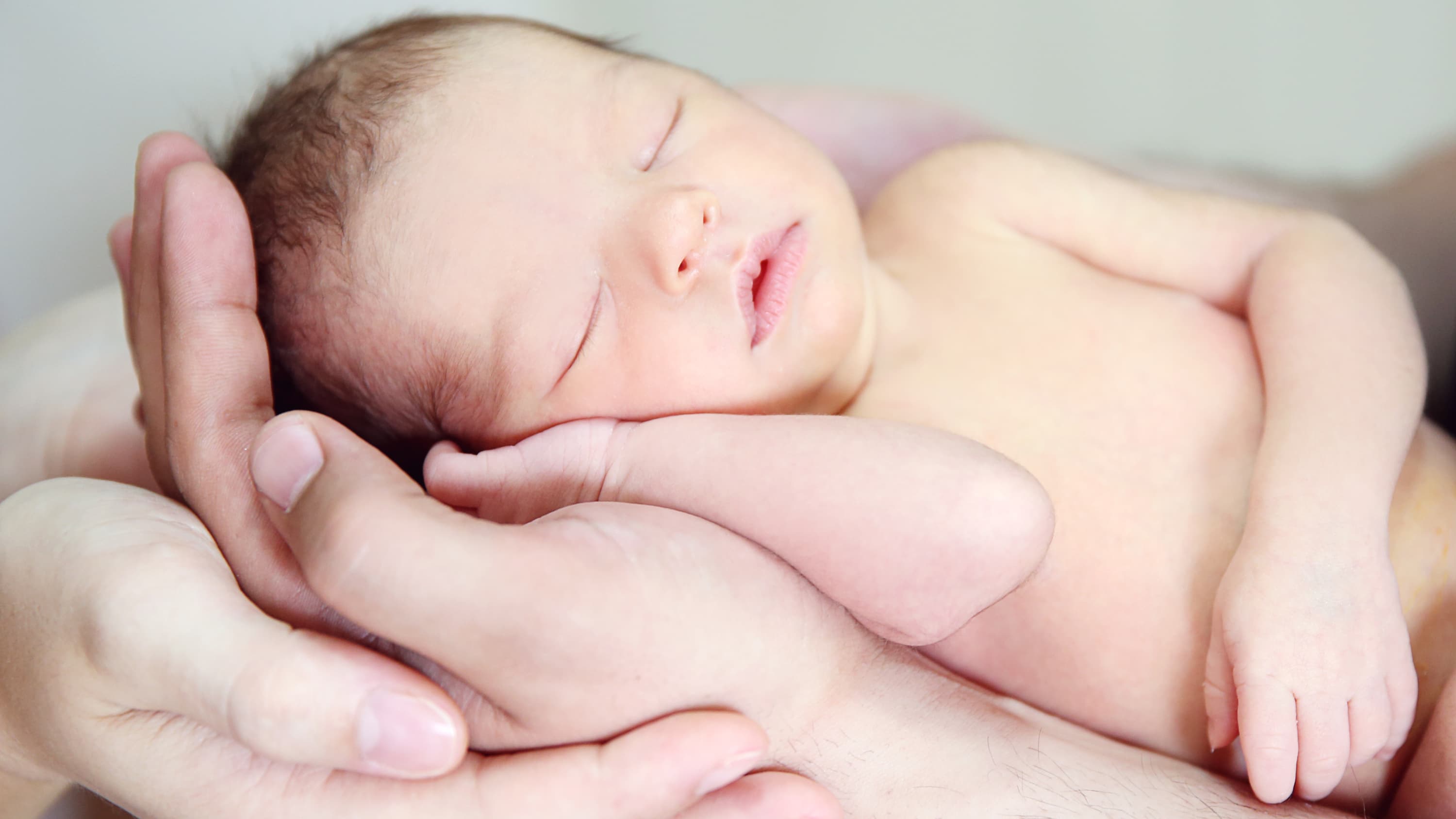 A parent holds a newborn with a congenital heart defect.