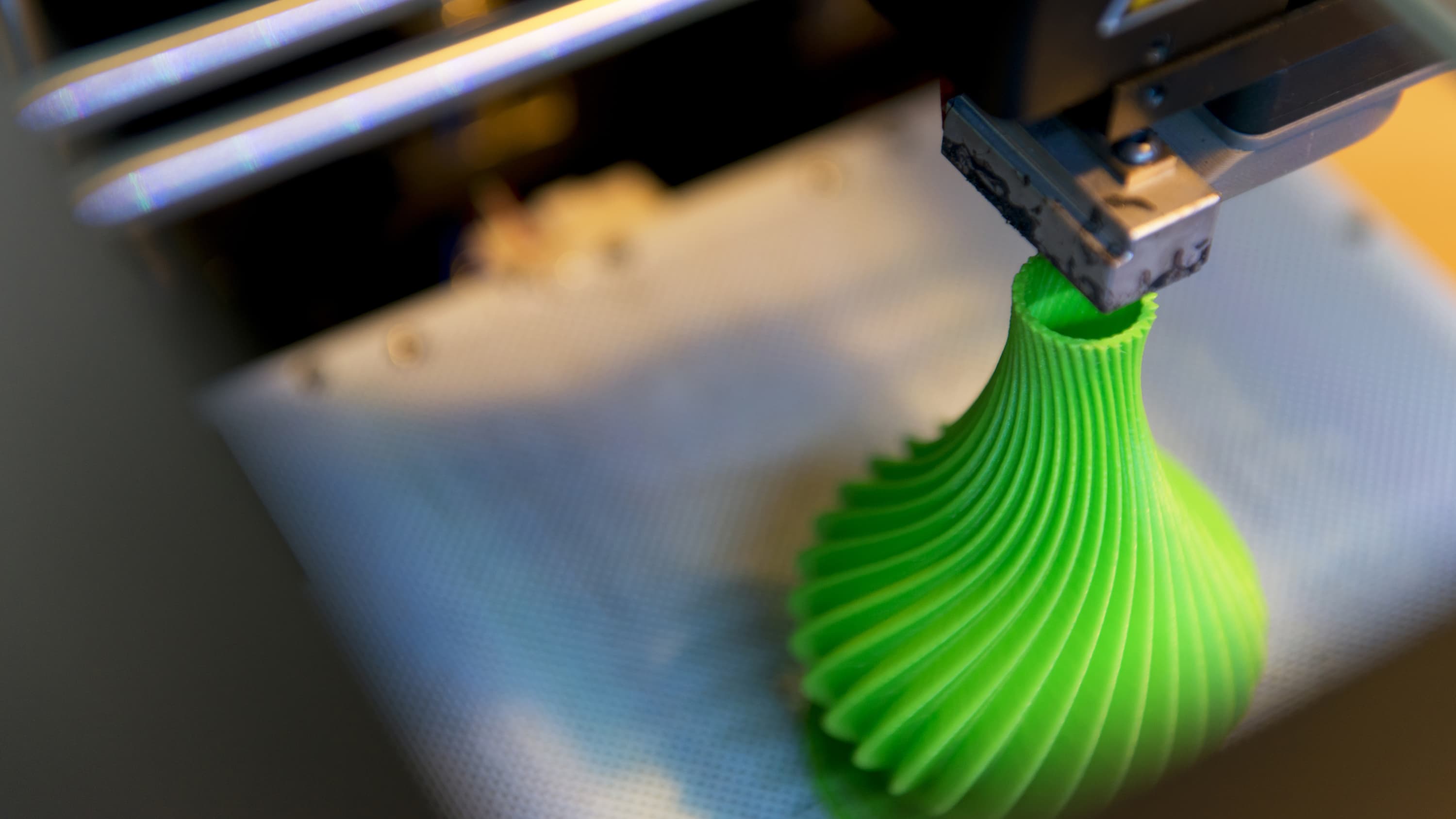 A 3D printer prints something green.