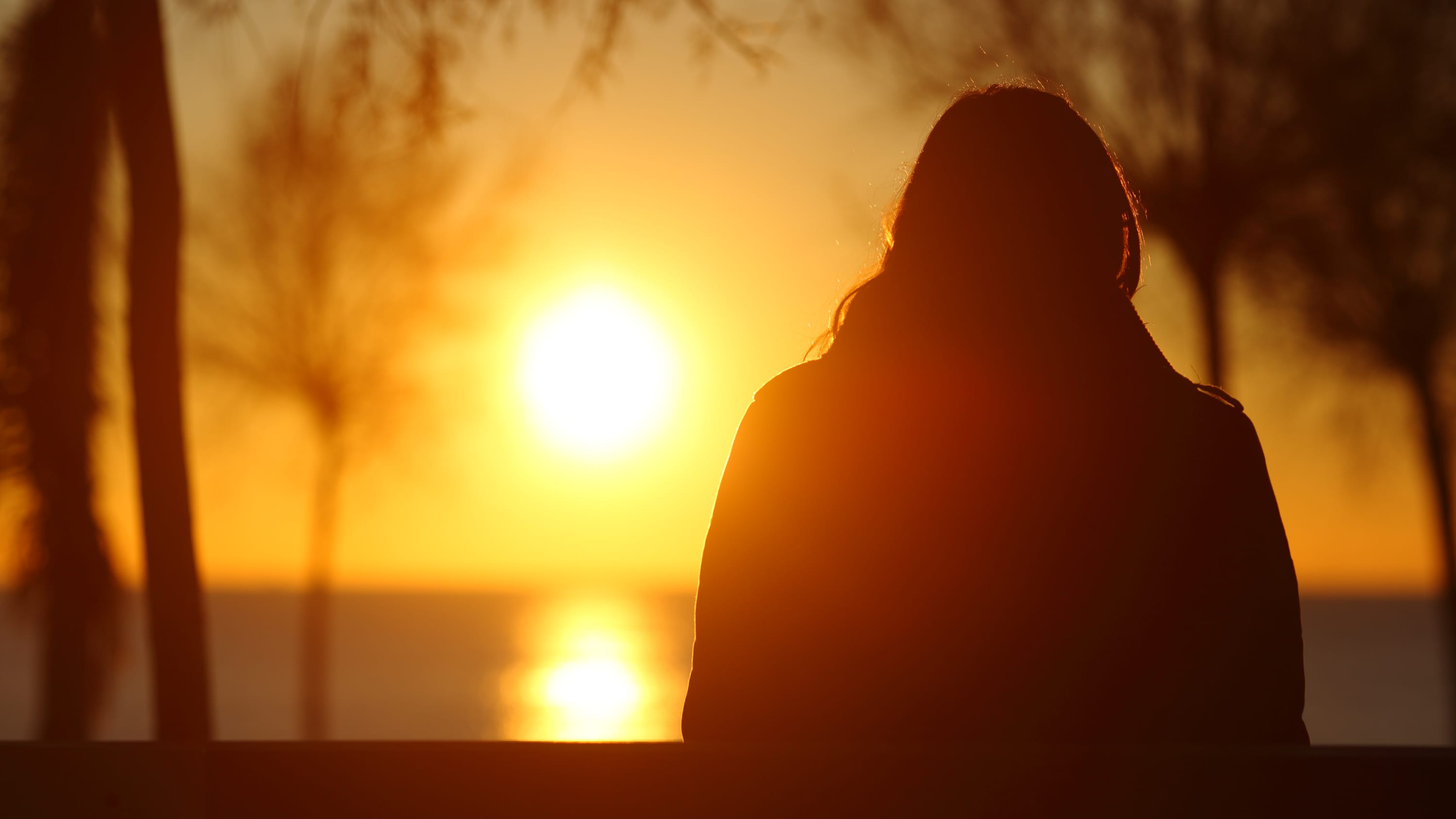 woman with seasonal affective disorder (SAD) looking at the sun, as possible light therapy