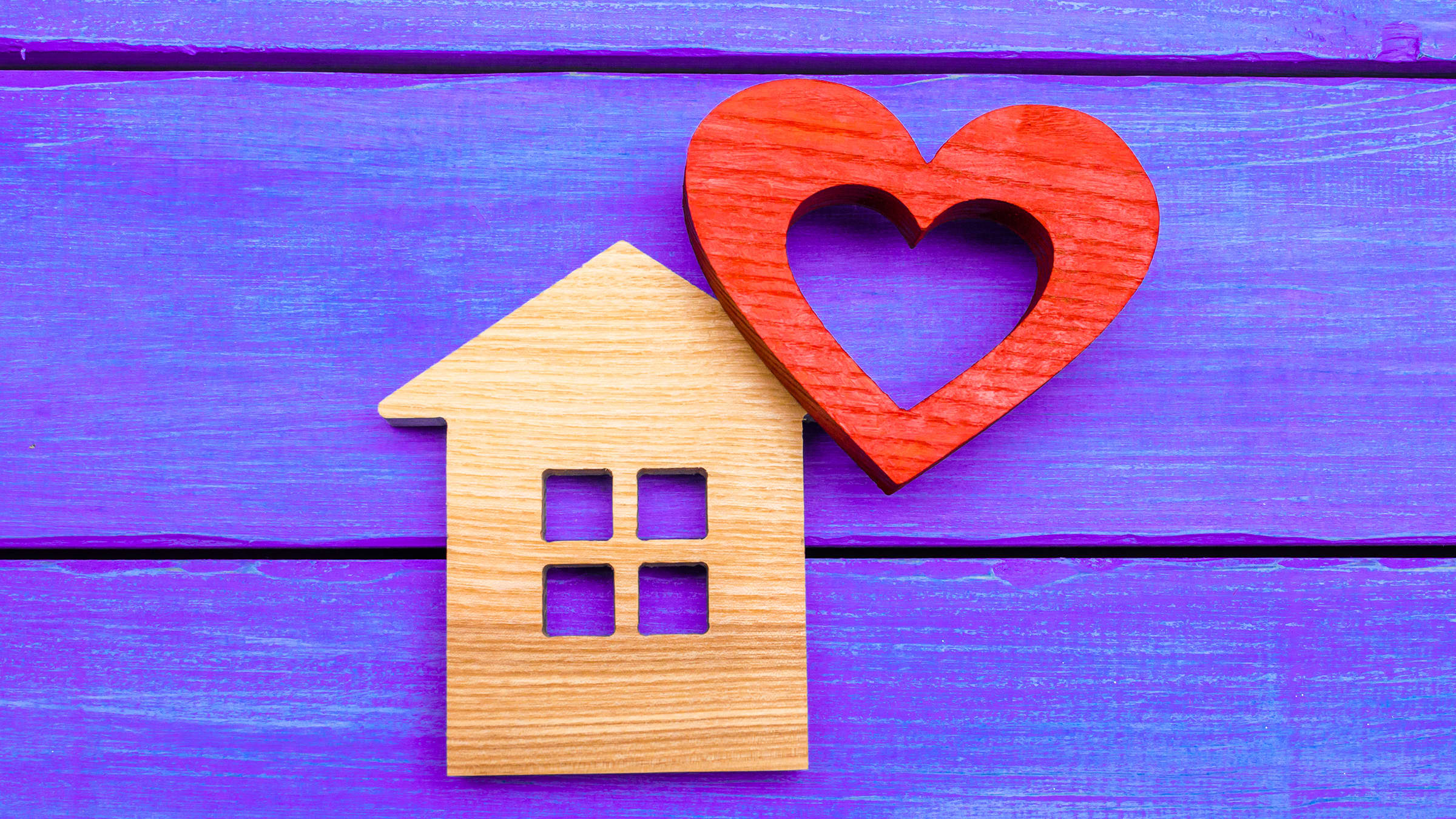 Wooden home cut-out with cut-out wooden heart, symbolizing Yale's home-based care programs