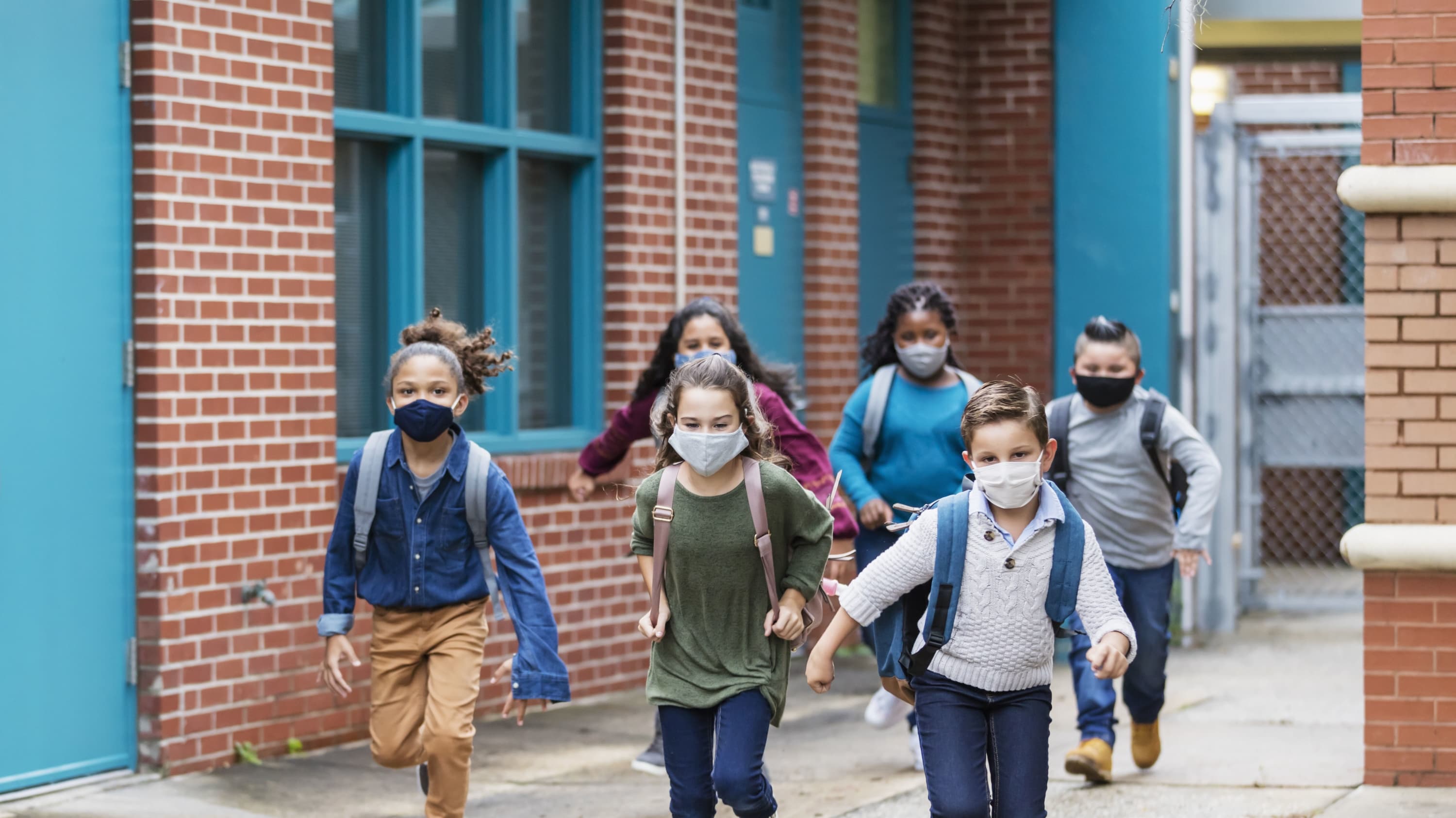 children running outside of school, after COVID-19 vaccination