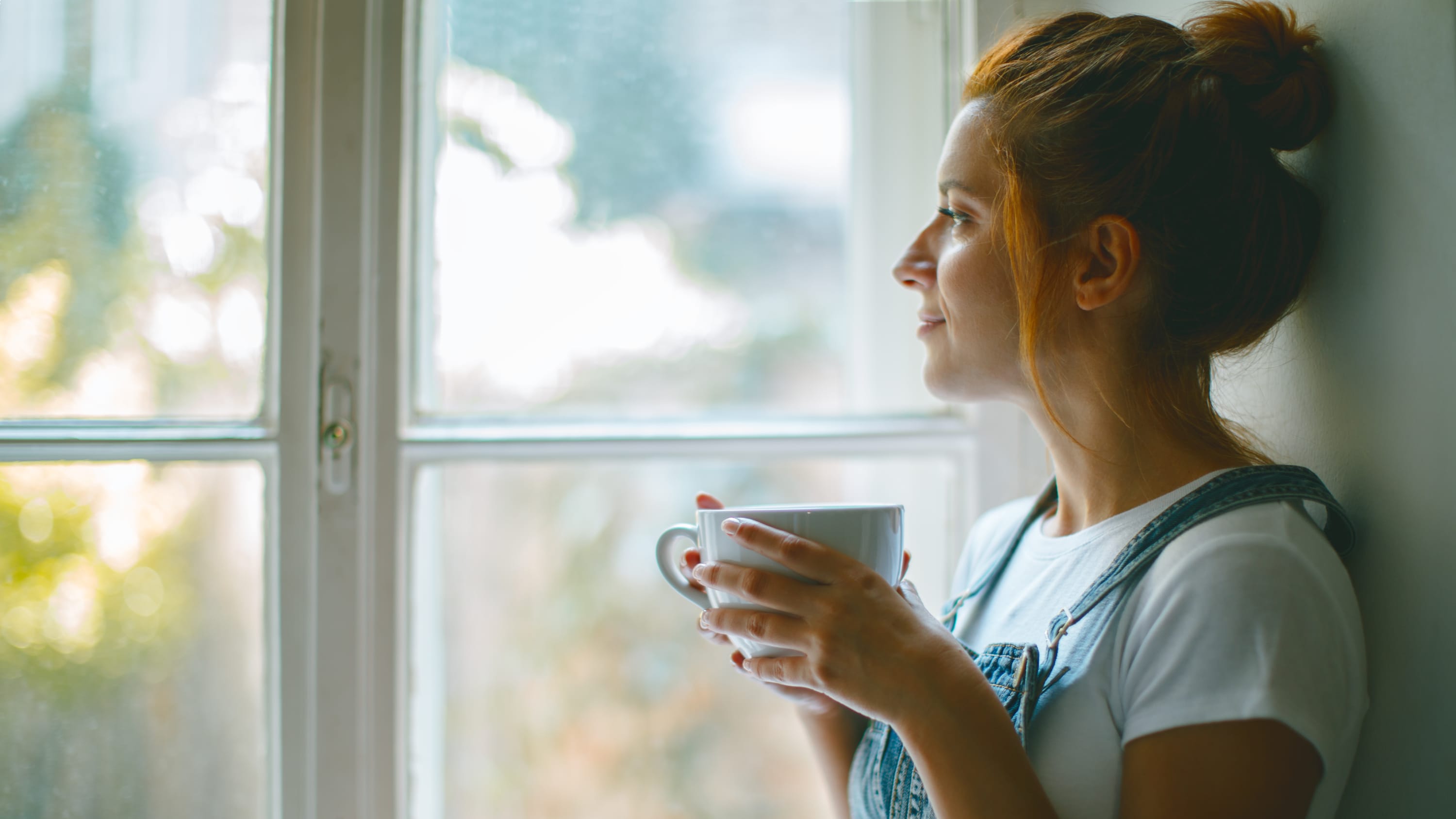 woman, who is a nonsmoker with lung cancer, looking out window after