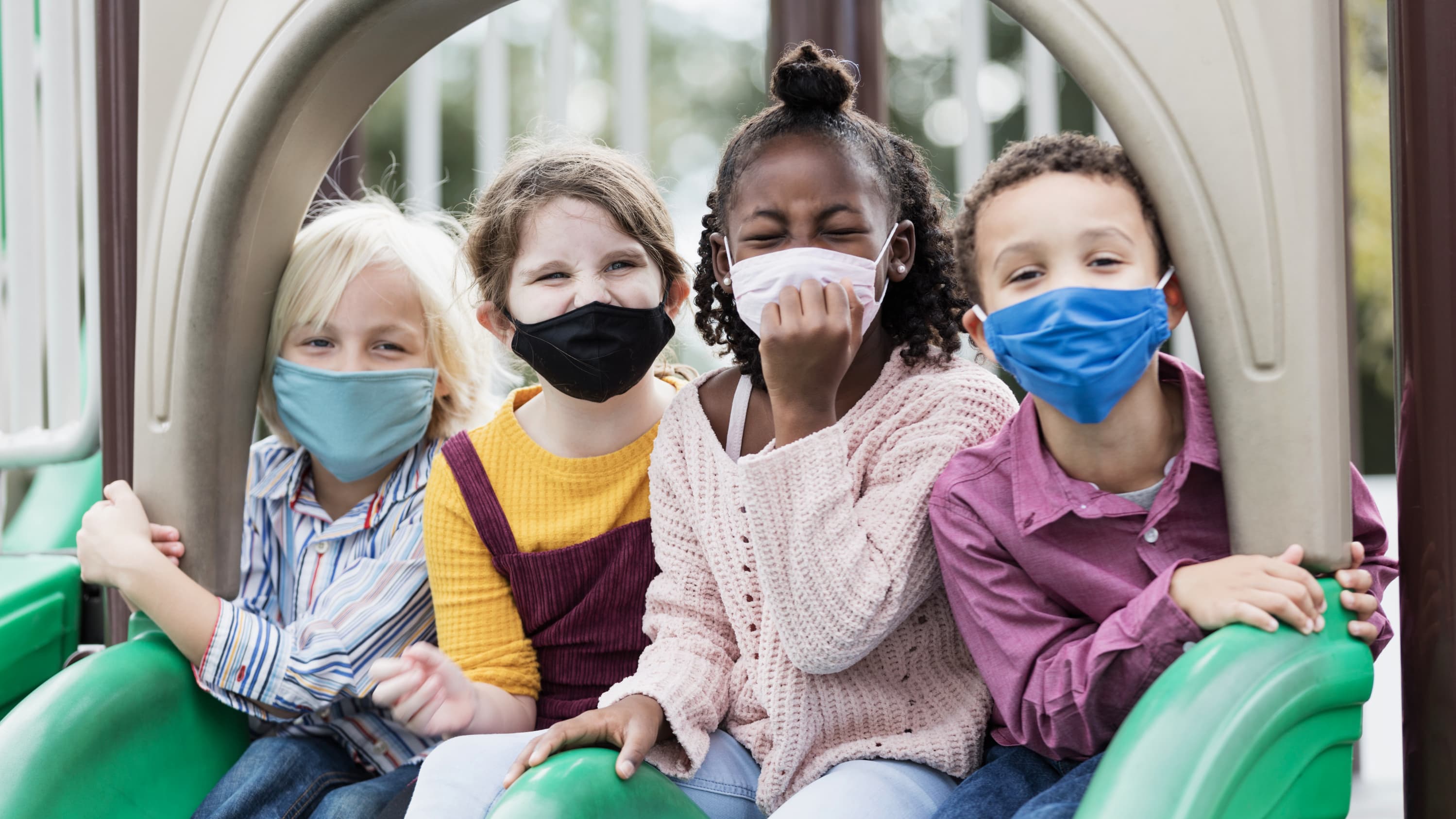 masked kids in a playground who might benefit from COVID-19 vaccine clinical trials