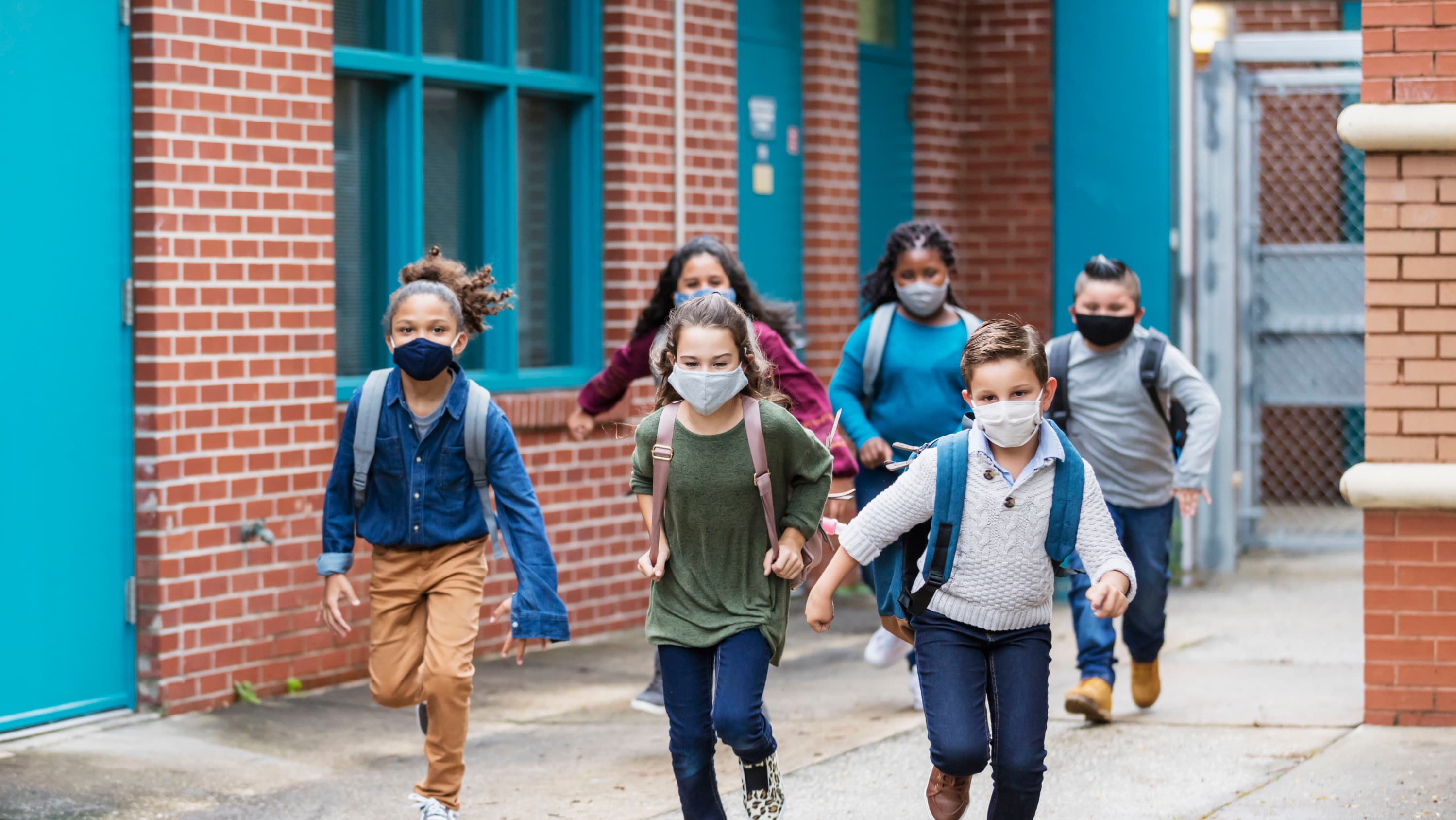 children running outside of school, after COVID-19 vaccination