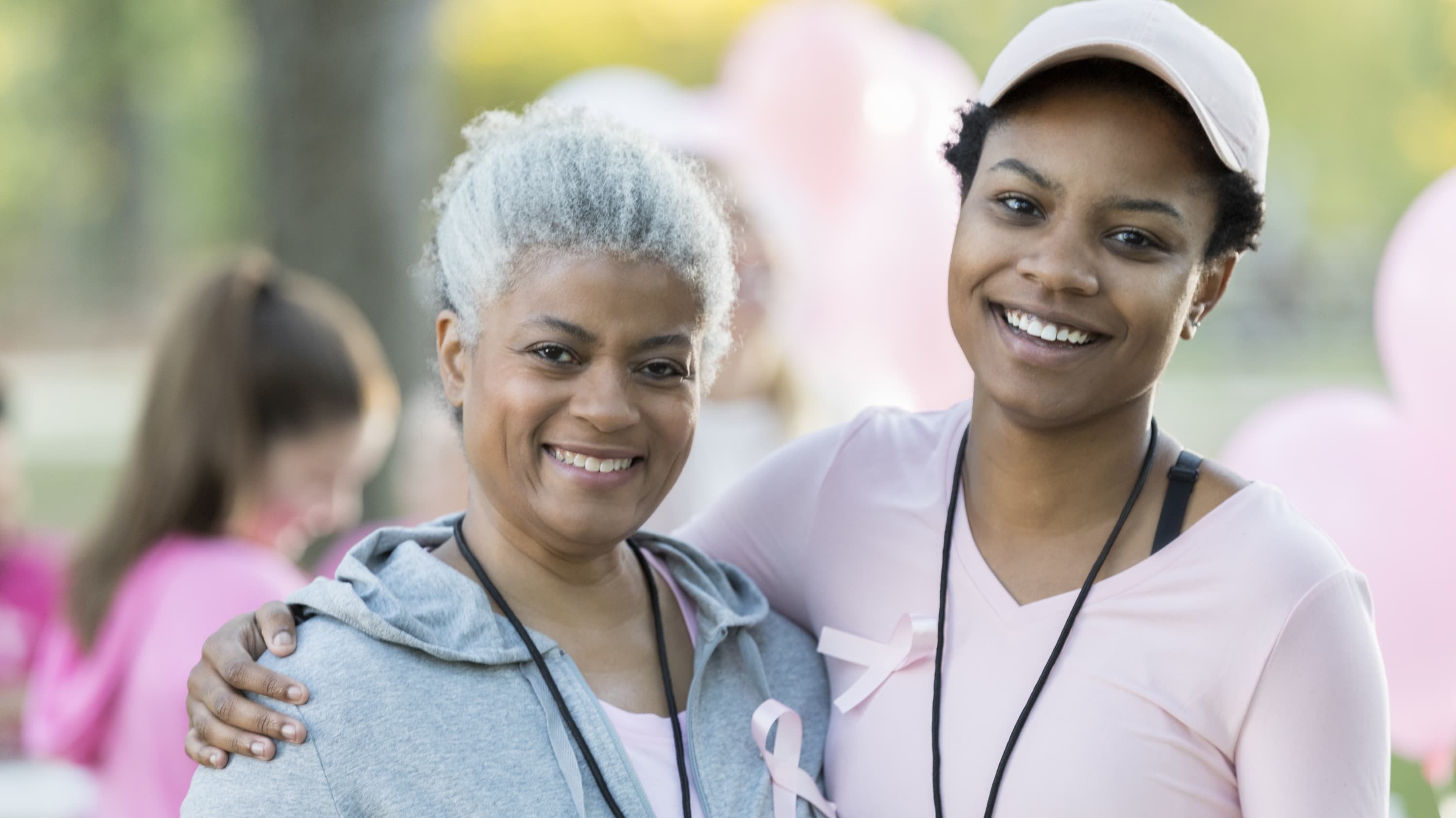 Senior woman and daughter smile for camera at race for breast cancer cure