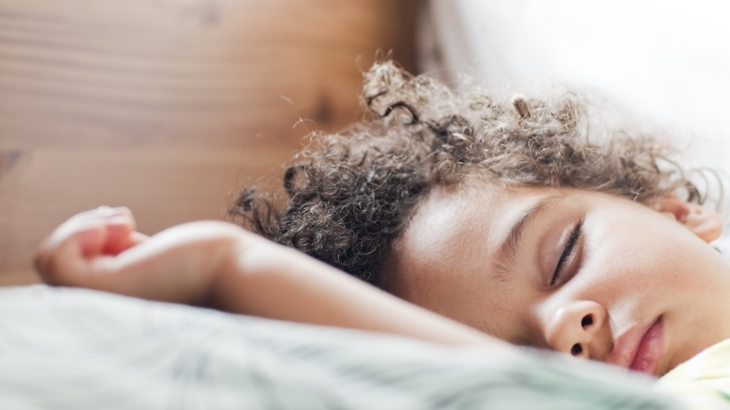 A little girl who may have obstruction sleep apnea is fast asleep in bed.