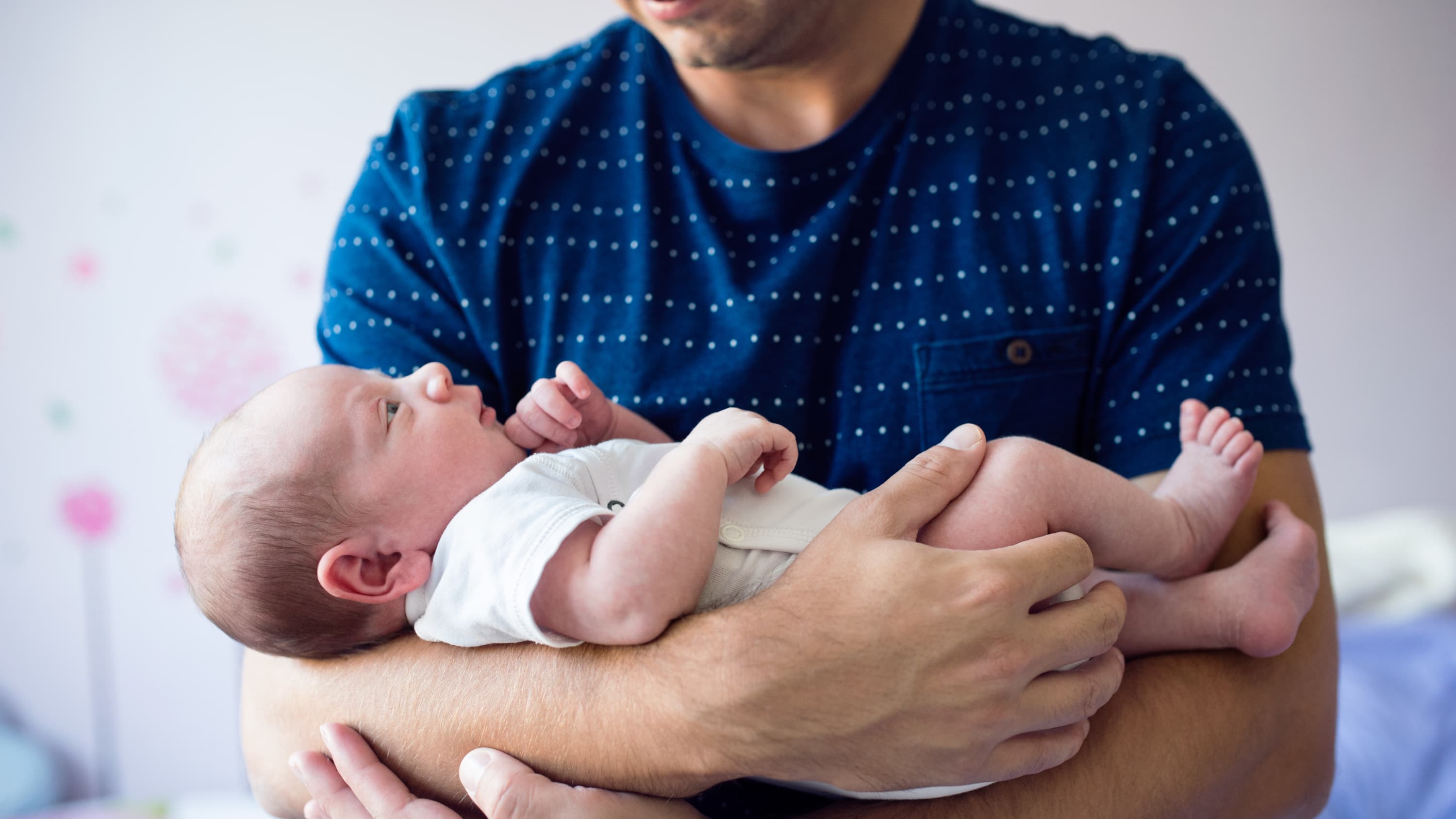 A father cradles a newborn son with a congenital heart defect.
