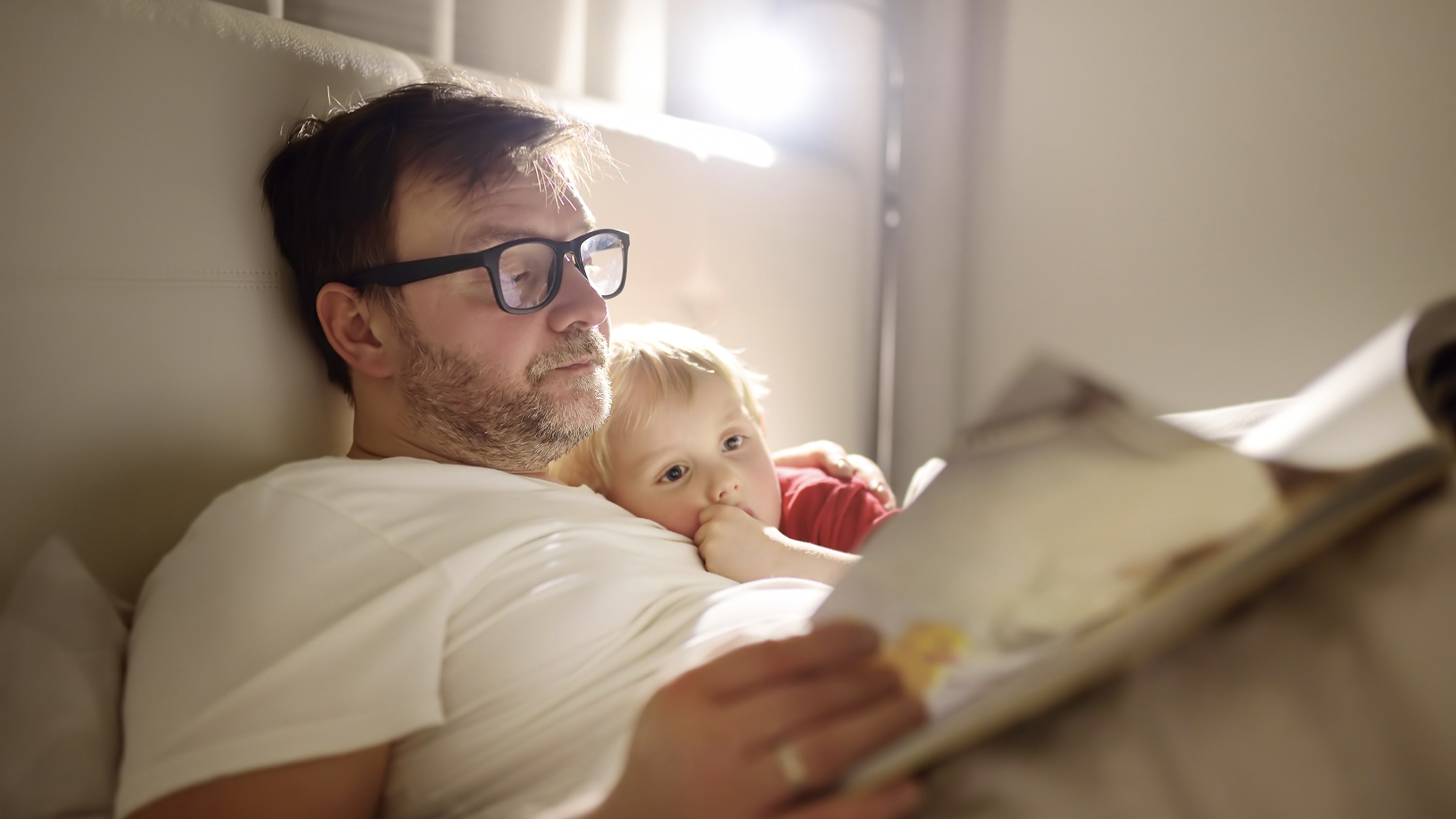 man reading with his child, unaware of his potential risk for HPV-associated oropharyngeal cancer
