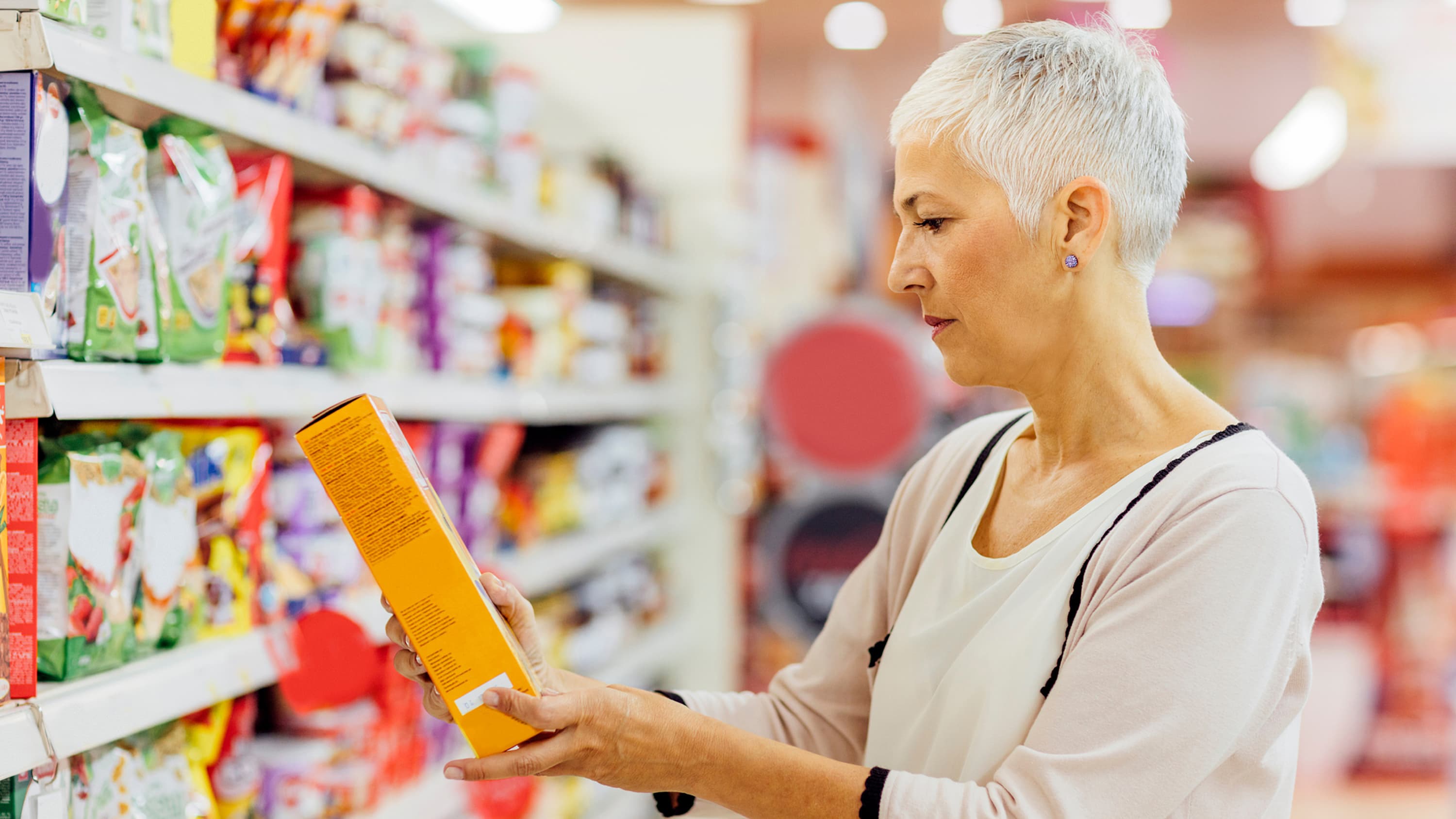 A woman examines a nutrition label, possibly for gluten.