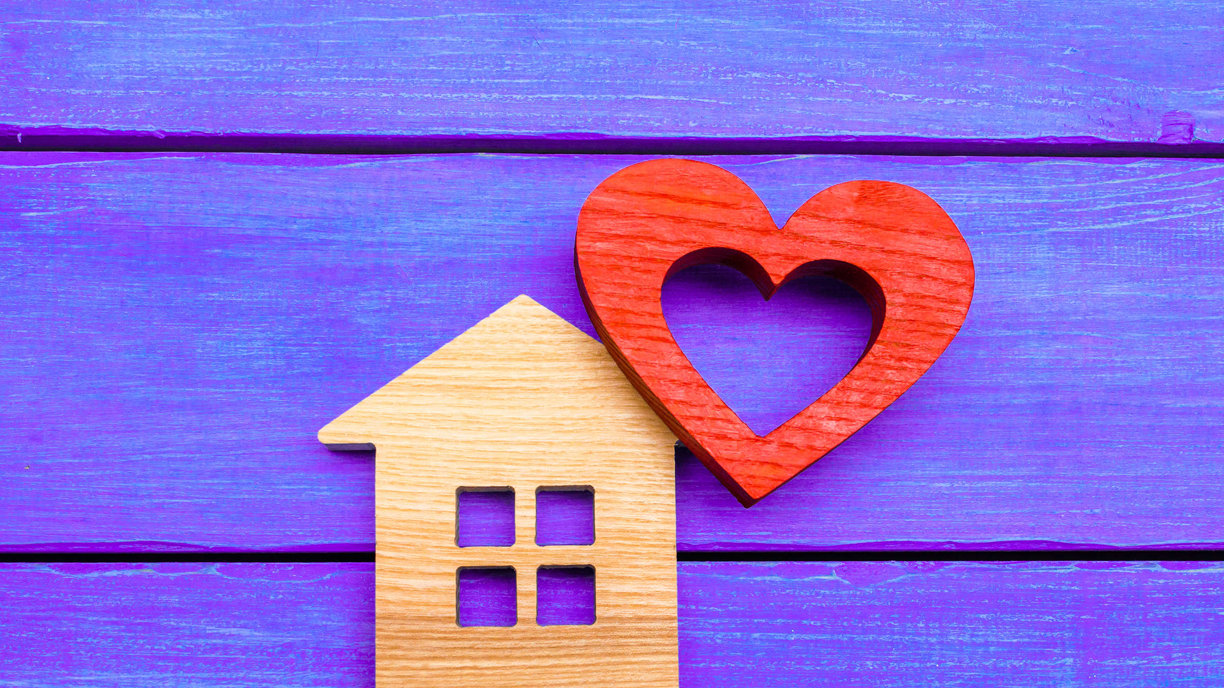 Wooden home cut-out with cut-out wooden heart, symbolizing Yale's home-based care programs