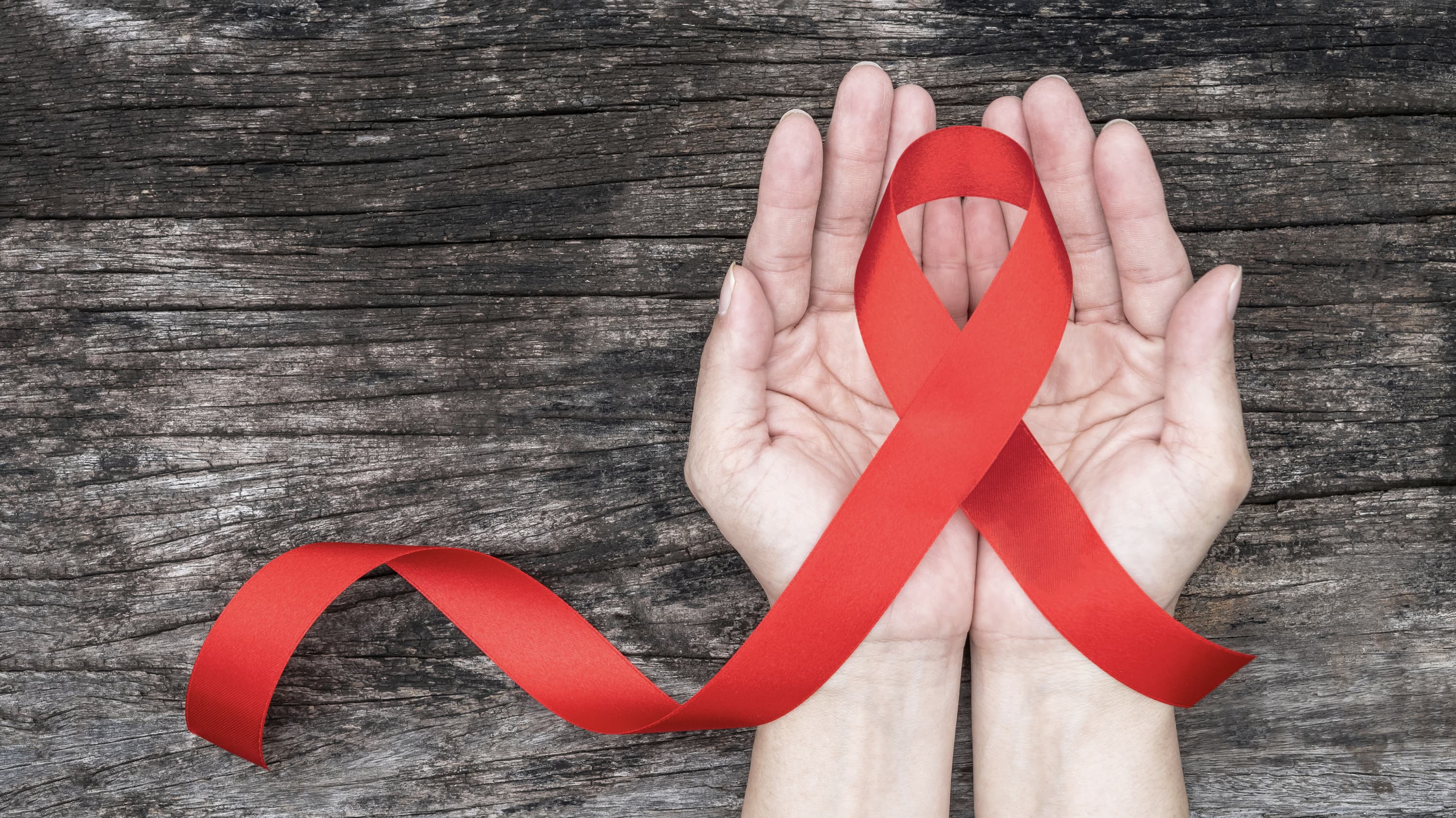 AIDS ribbon in an open hand