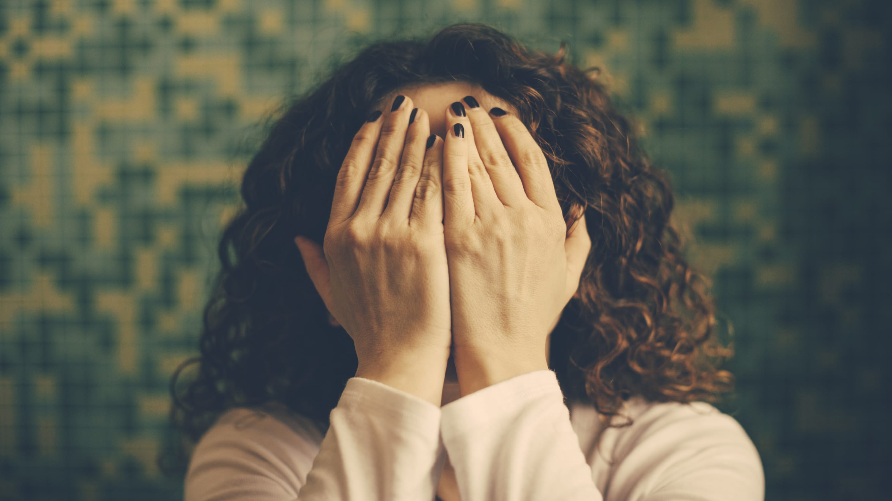 woman with hands over face, embarrassed about common gastrointestinal issues