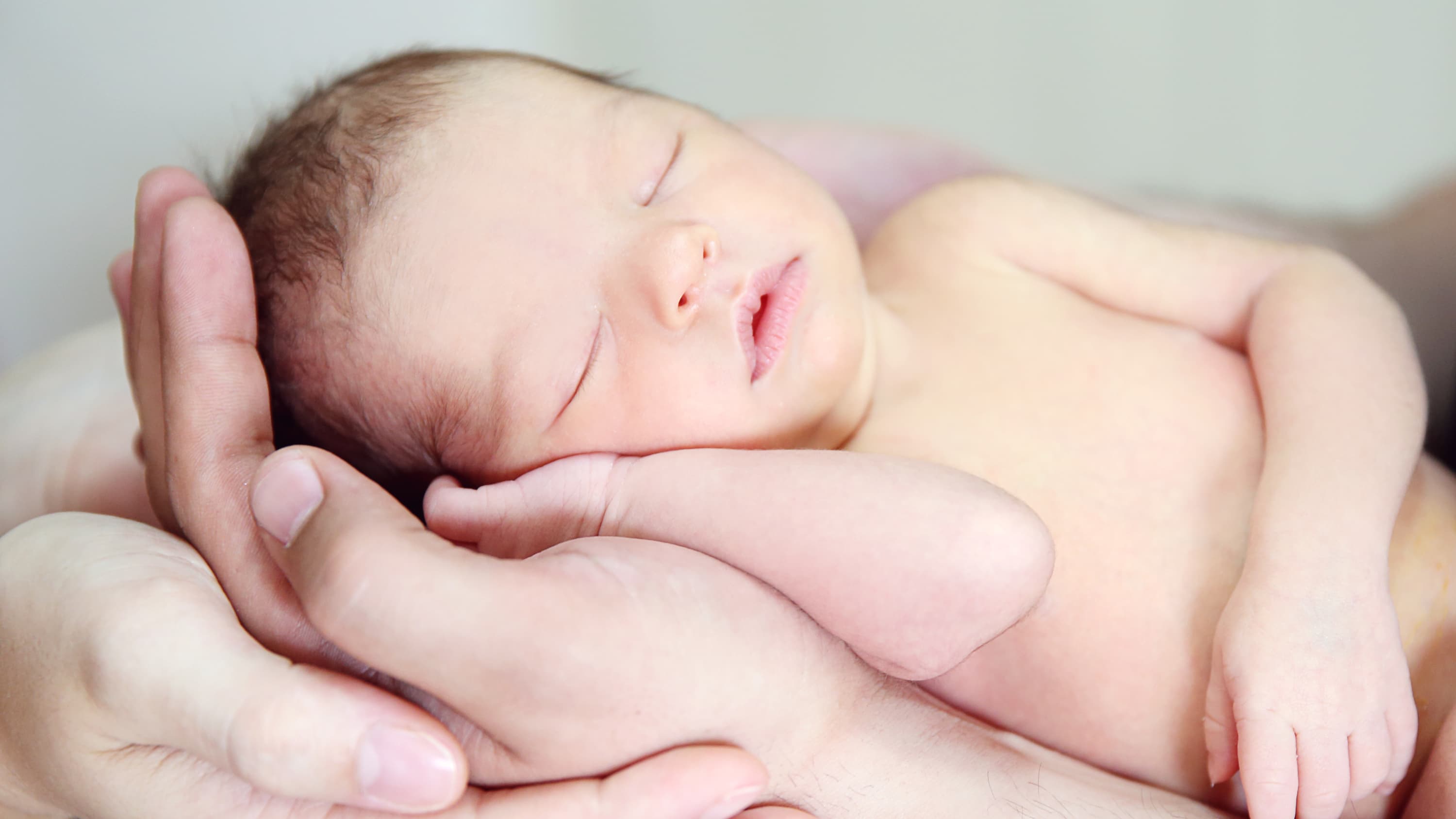 A parent holds a newborn with a congenital heart defect.