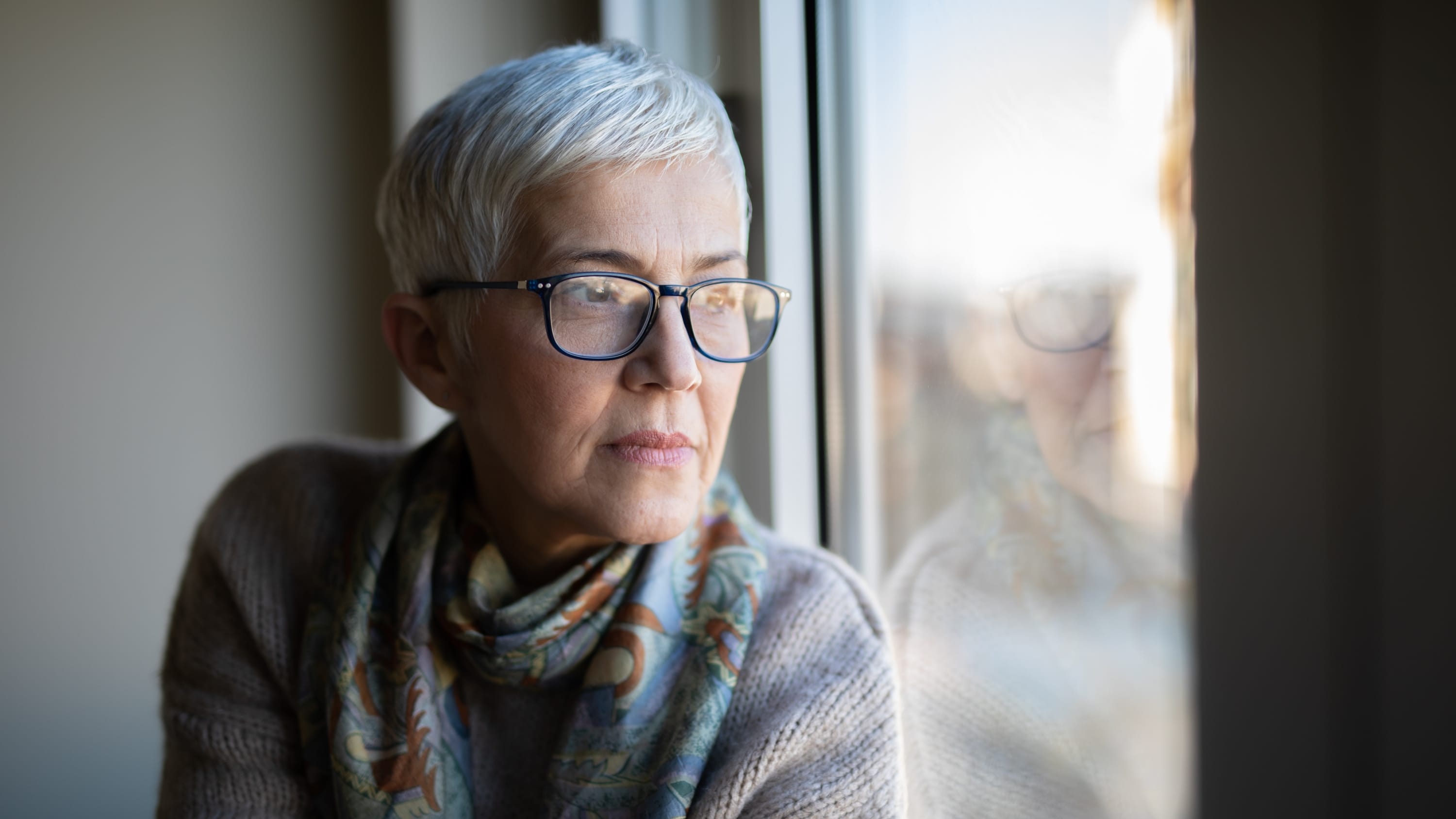 woman looking out window after a hysterectomy