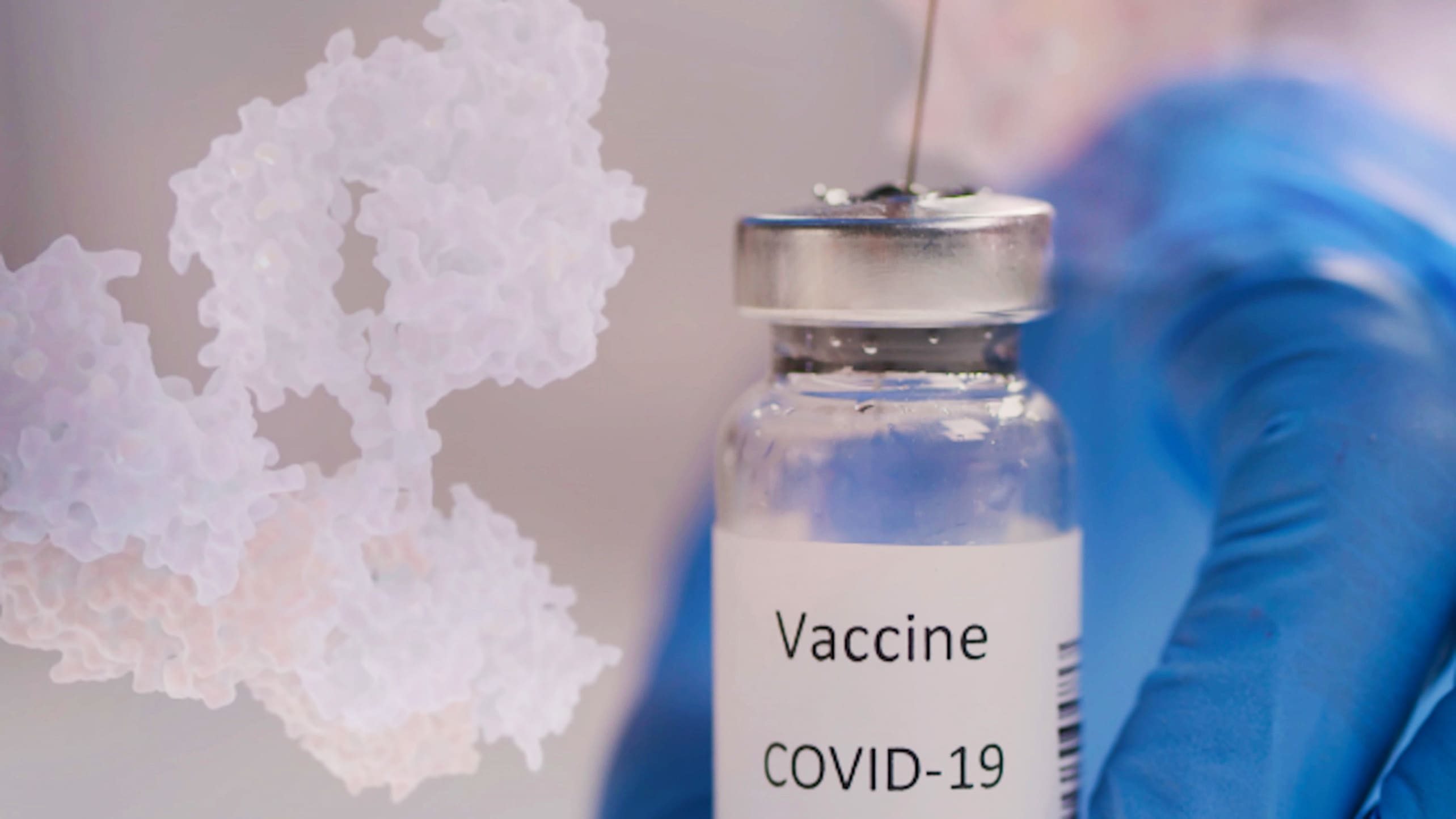 A syringe goes into a vial containing the COVID-19 vaccine.