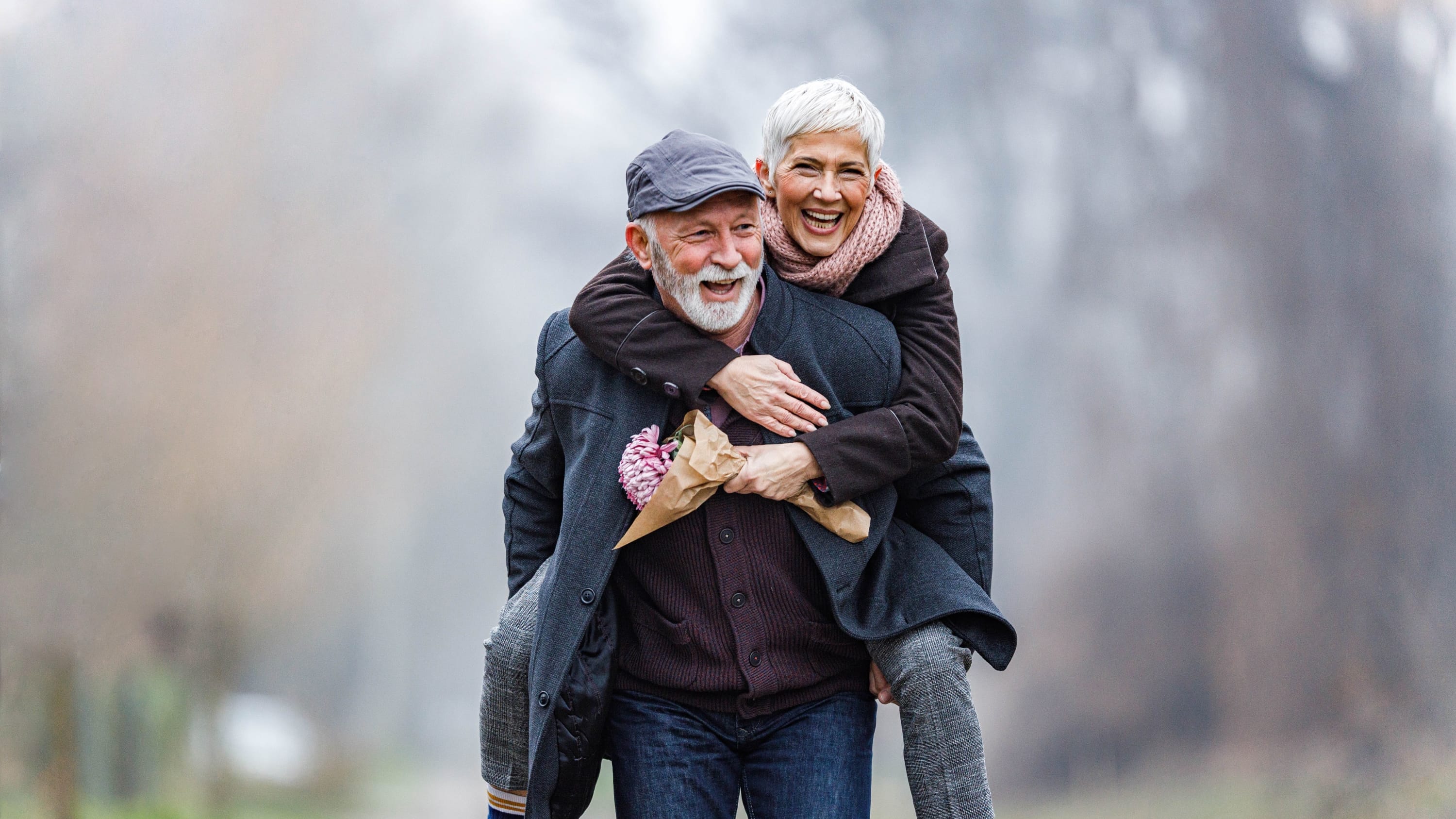 older couple giving piggyback rides after treatment for hematuria