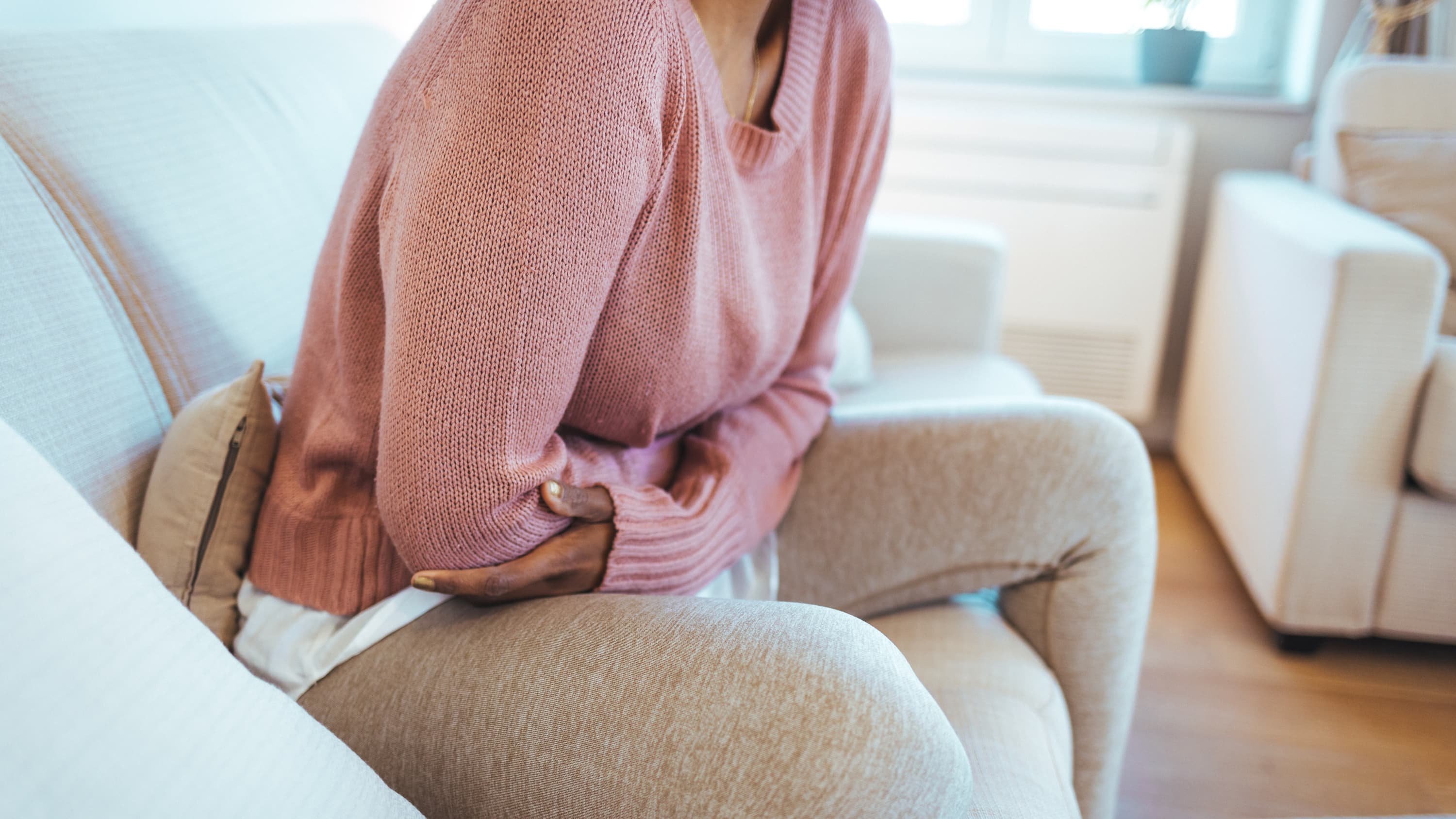 woman with pelvic pain from endometriosis on her couch