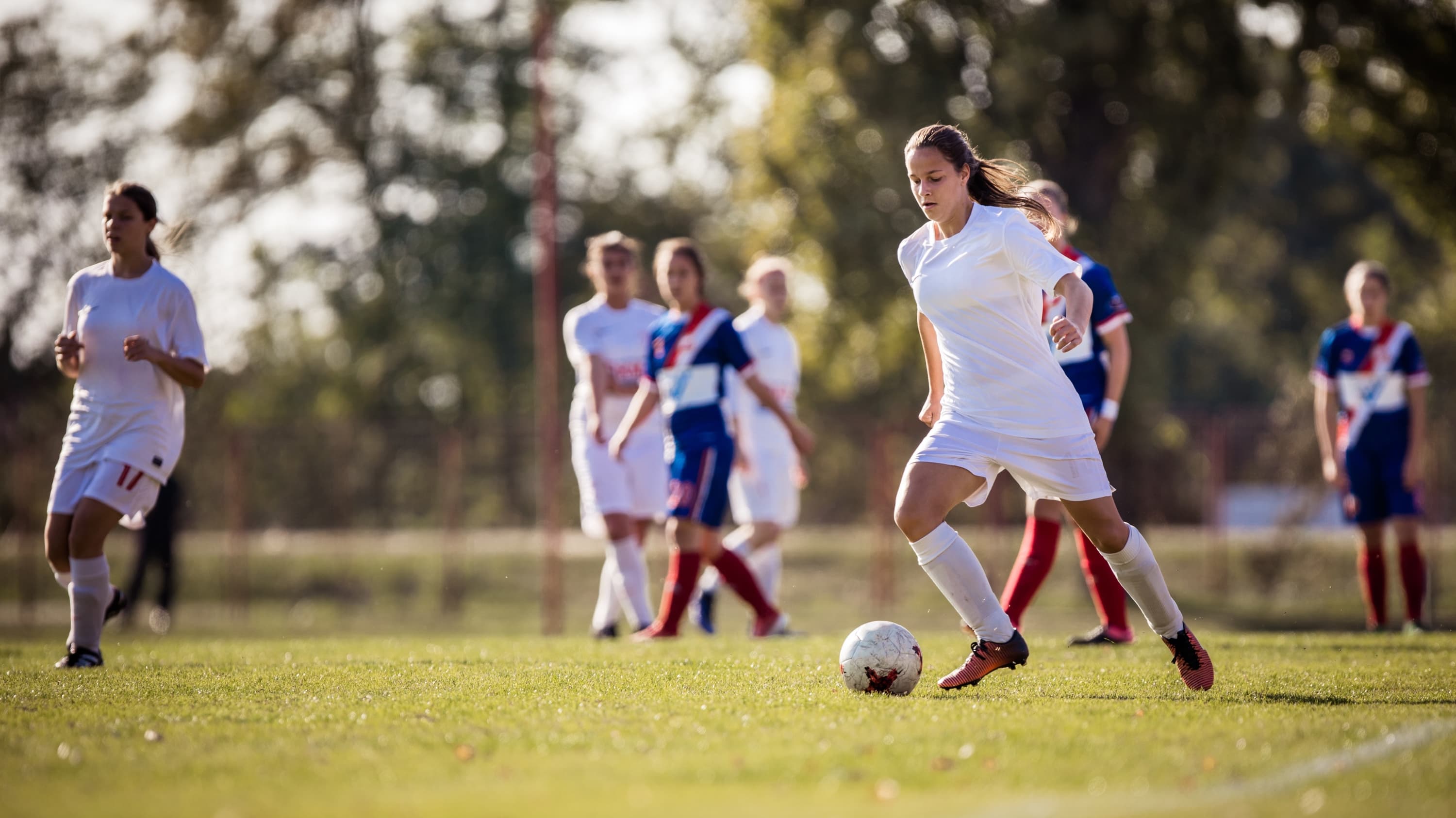 female soccer player, dribbling soccer ball, possibly before an injury to articular cartilagge