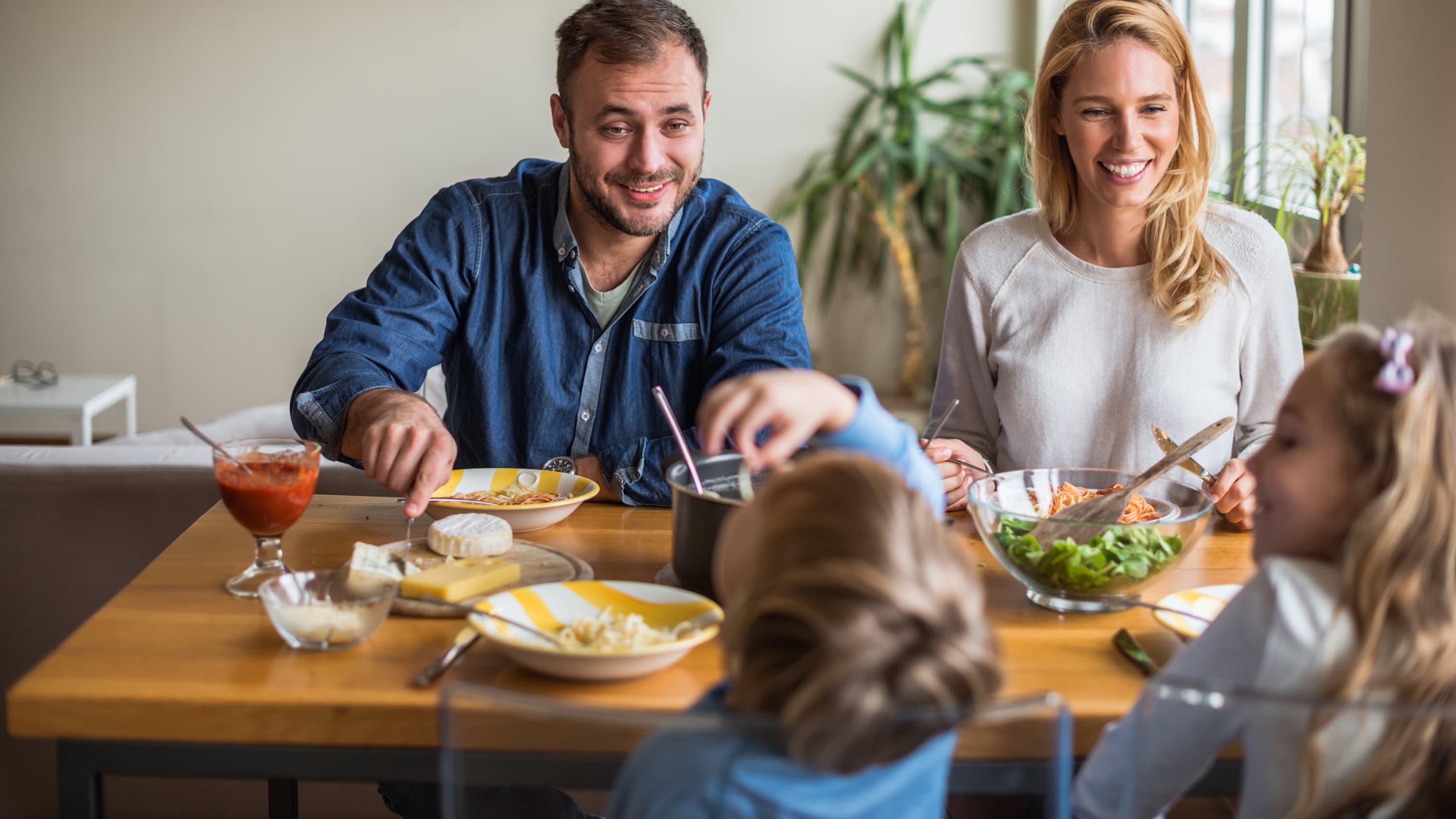 A father who may have had a vasectomy sits down to eat with his wife and children.