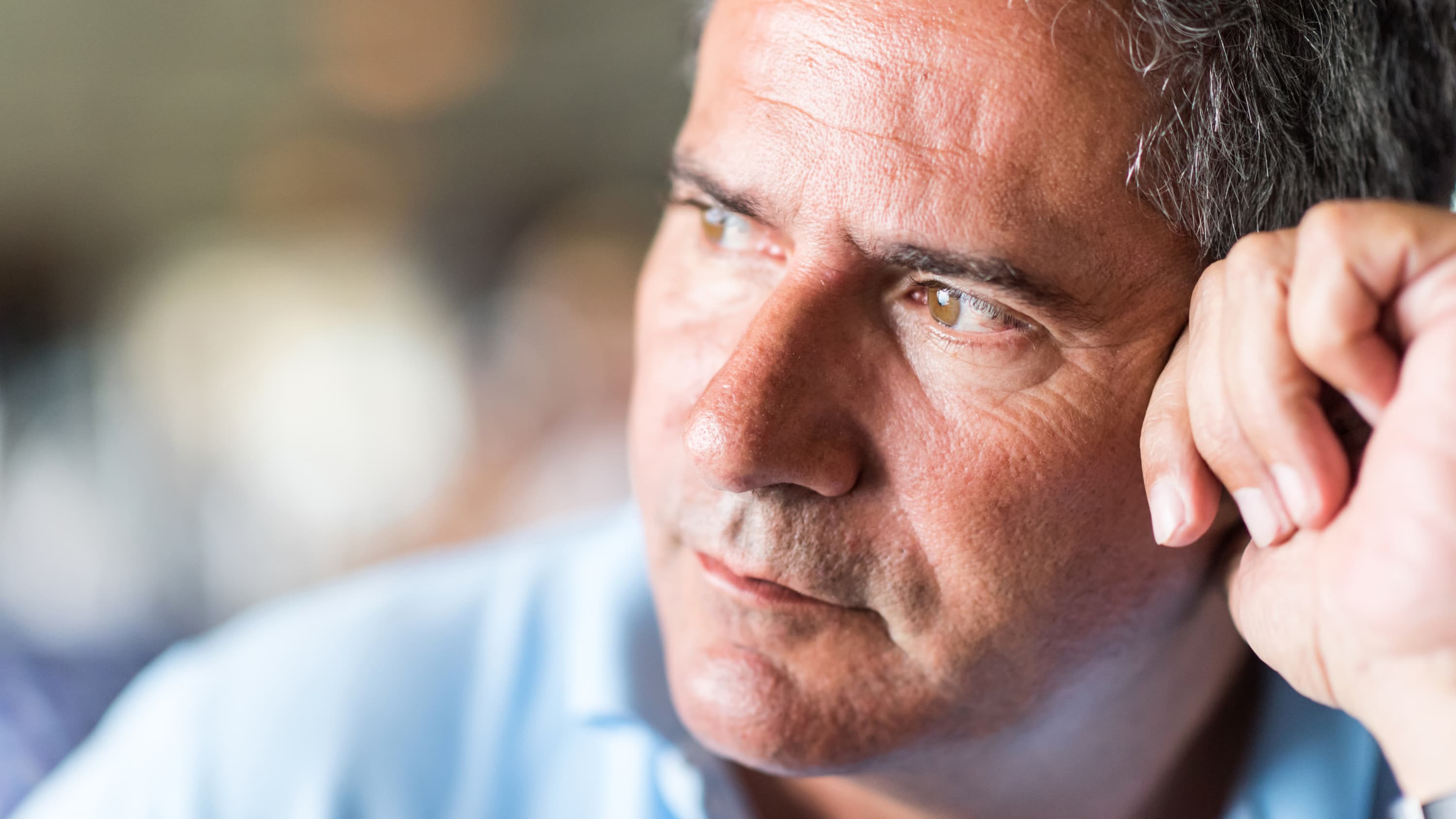 A man looks thoughtful, possibly thinking about erectile dysfunction