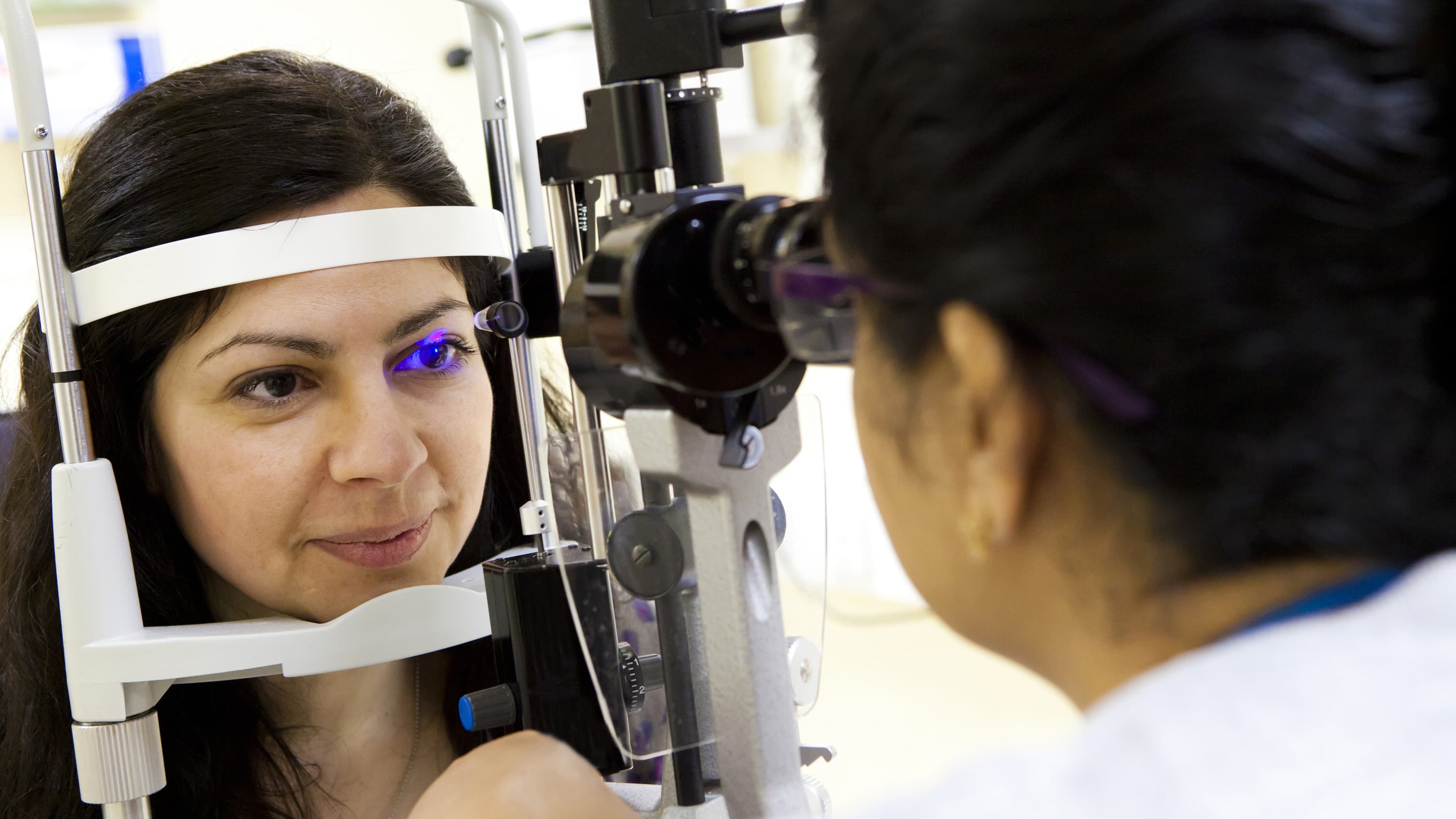 A woman has an eye exam, possibly for glaucoma