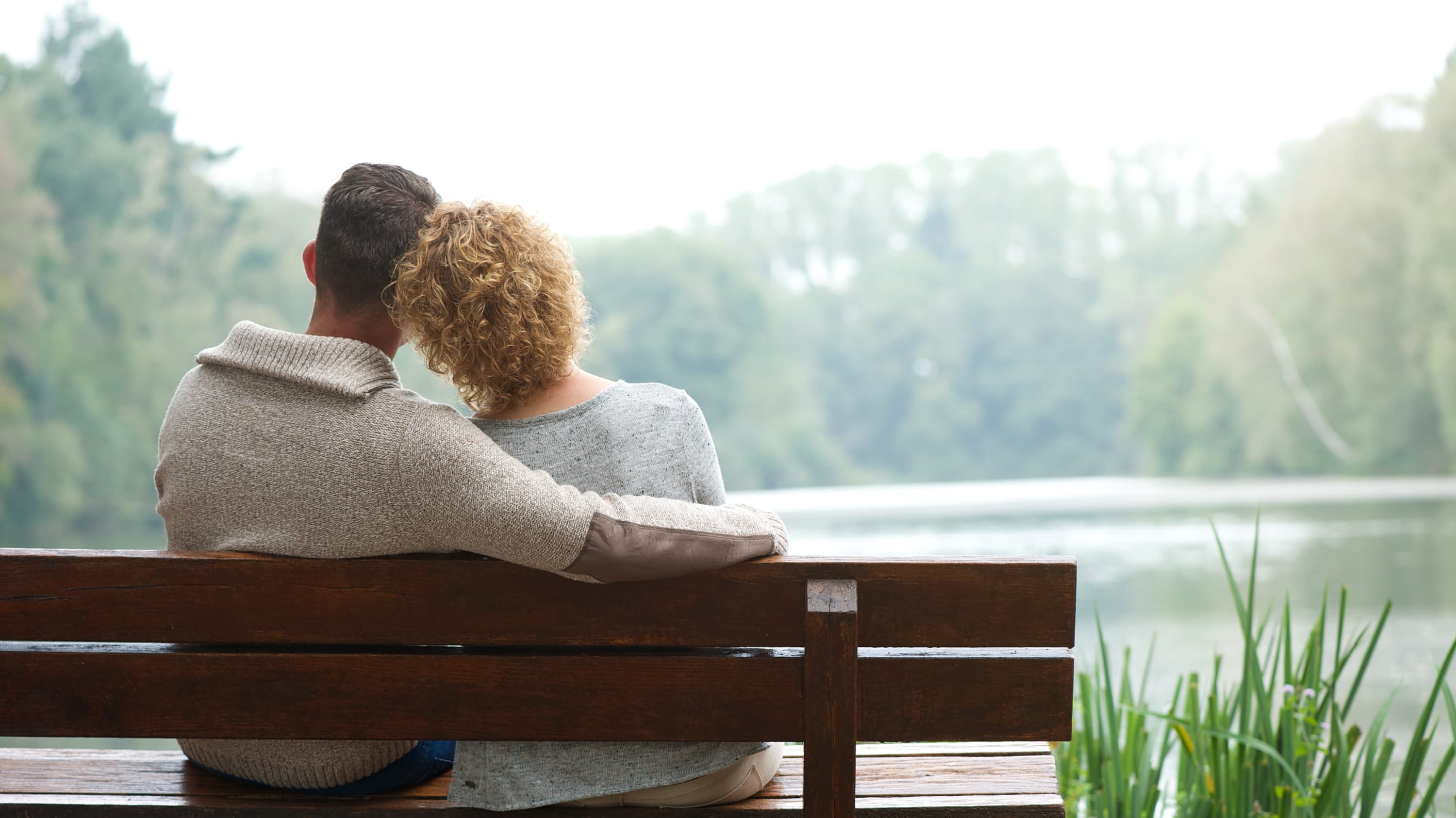 A couple sits and thinks on a park bench, considering female infertility