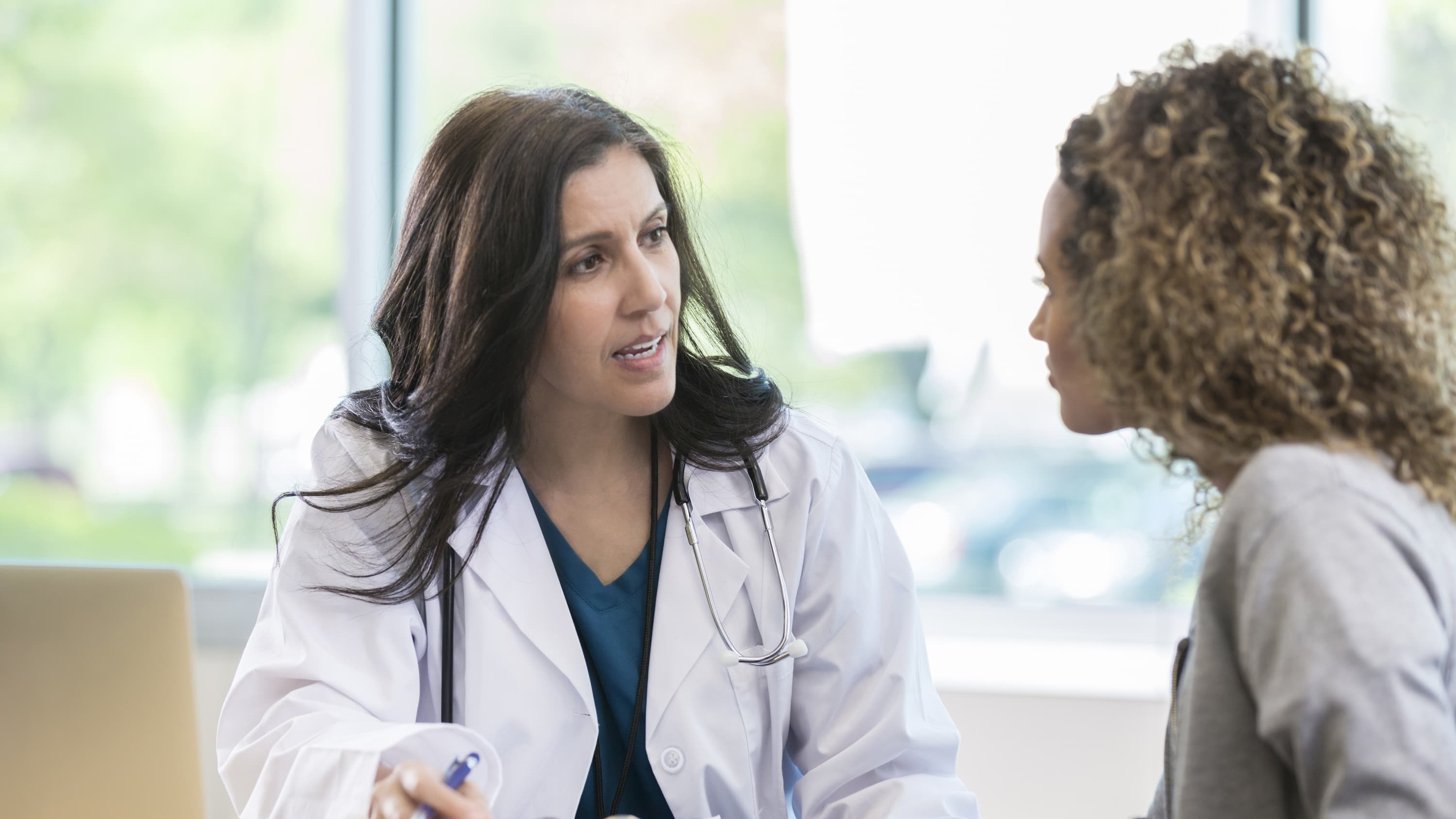 A doctor speaks with her patient, possibly discussing cervical insufficiency