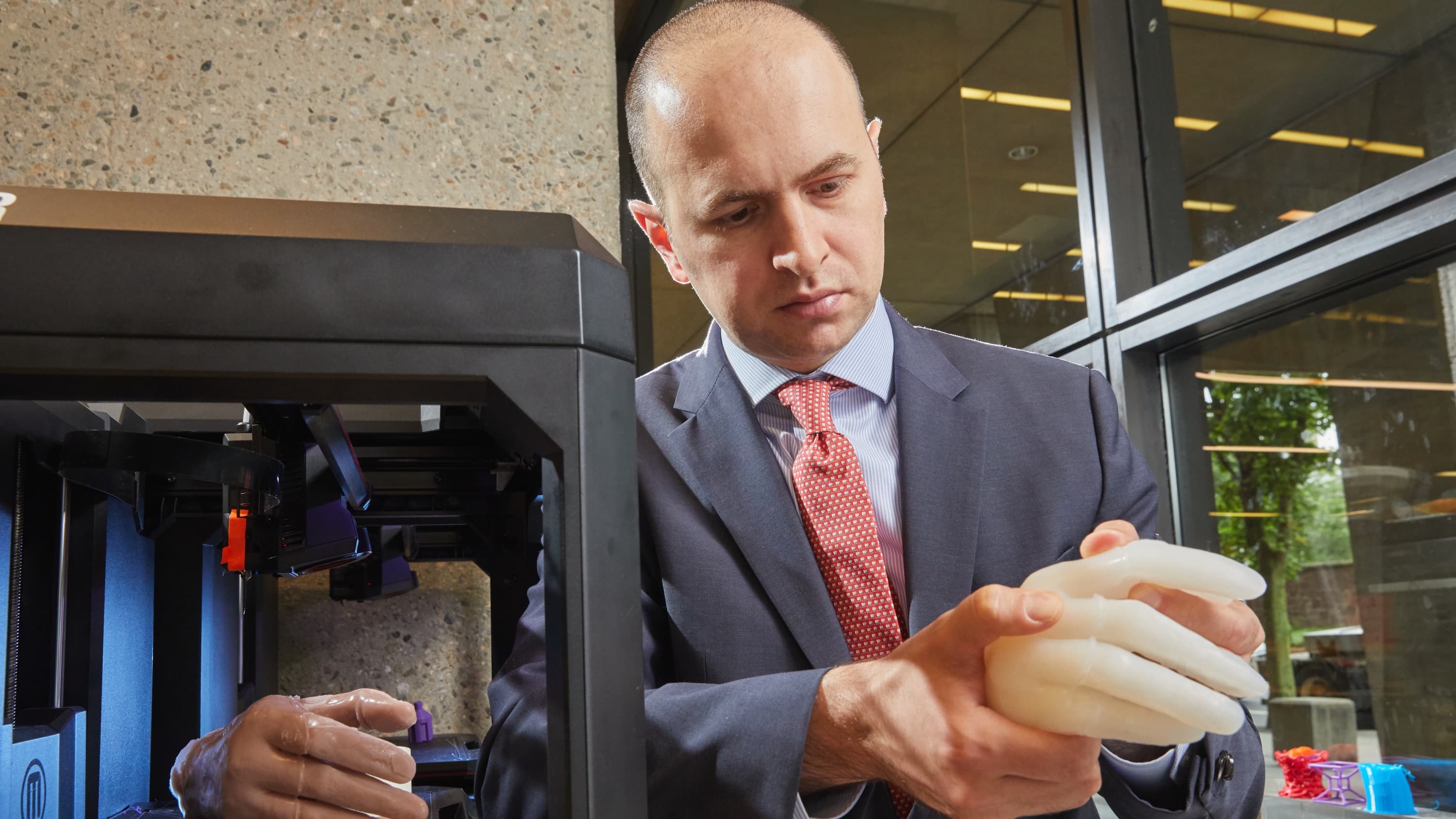Dr. Adnan Prsic holding a 3D-printed model of a hand