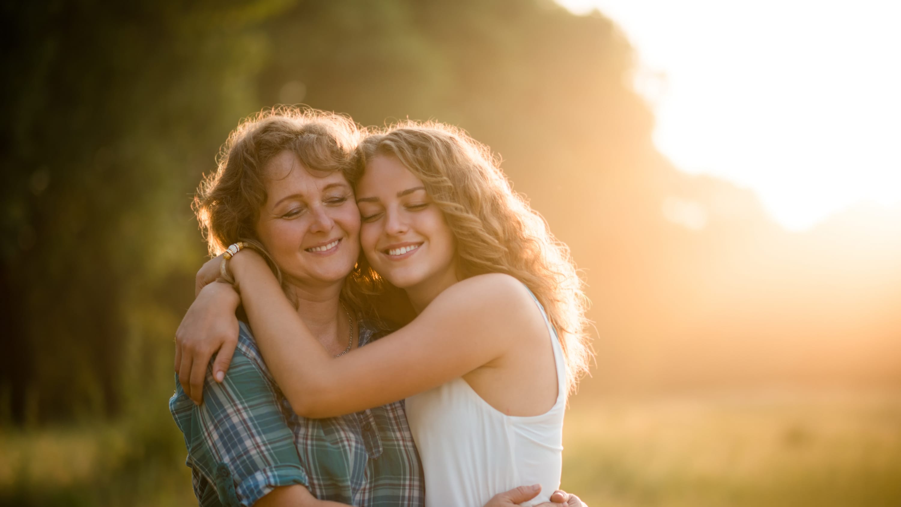 A mother and her teenage daughter, who has congenital heart disease, embrace.