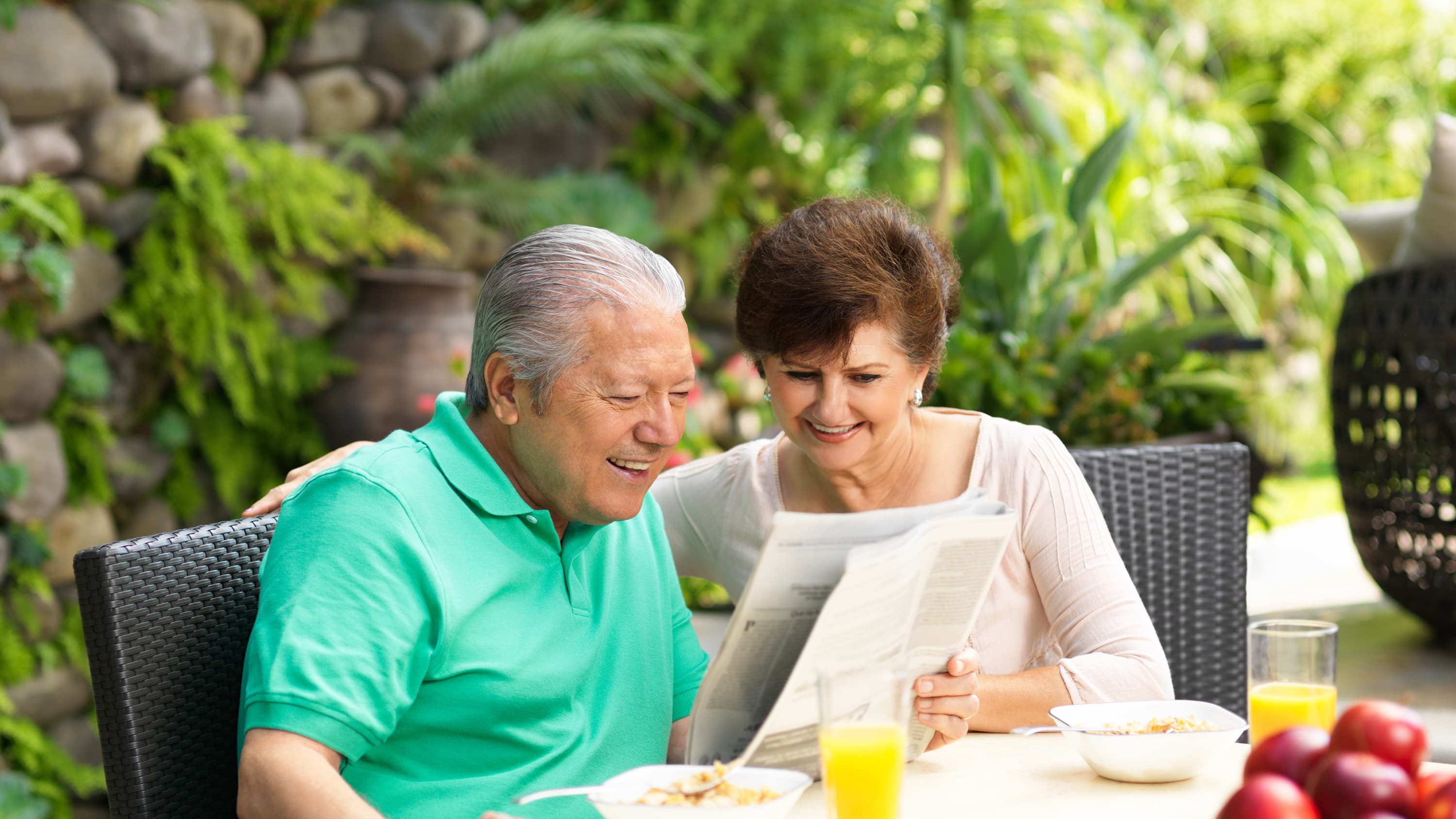Senior couple reading newspaper while eating breakfast. Telomere research may uncover the secrets to living longer. 