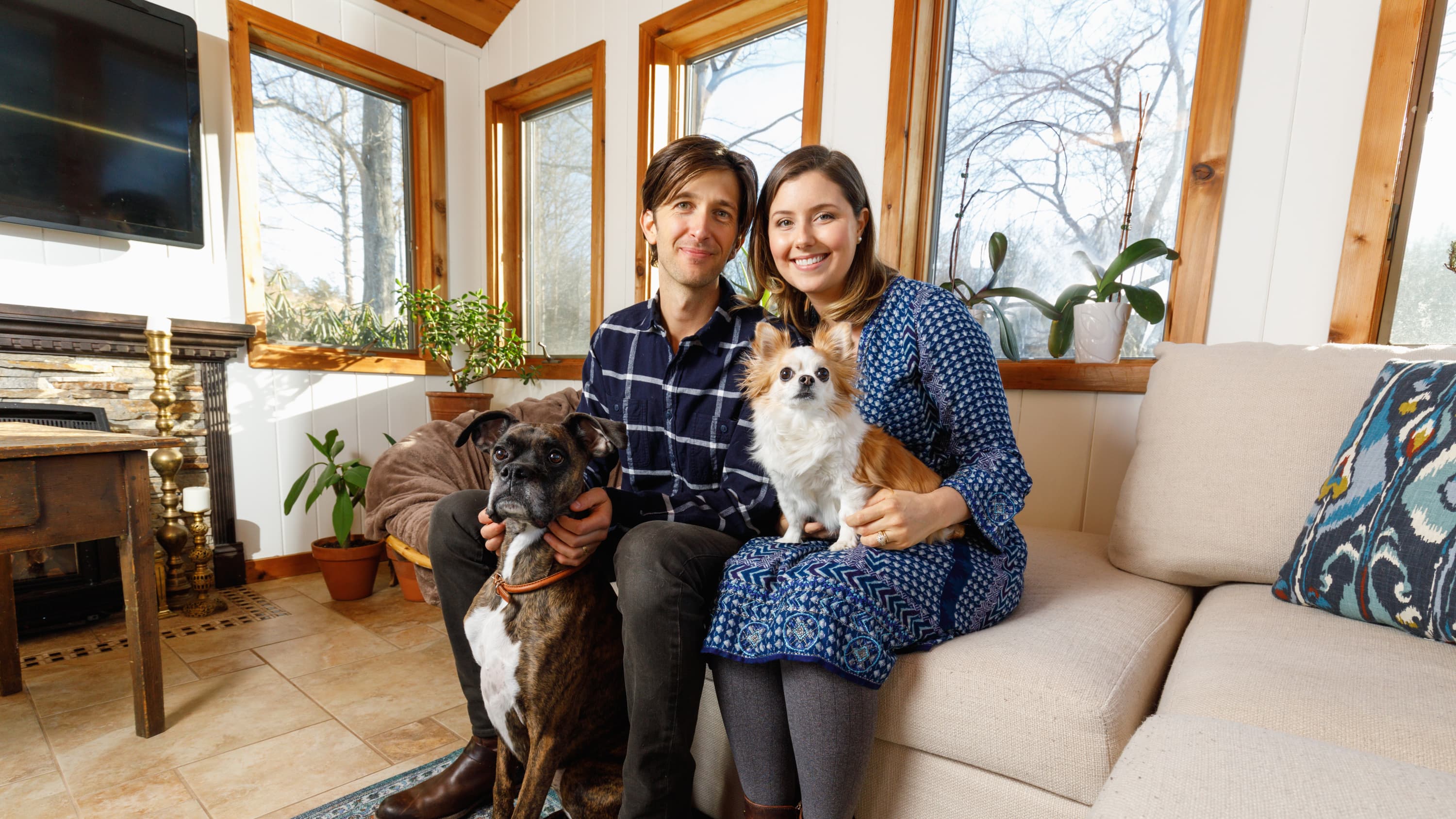 Marcus and Laura Gordon with their two dogs on the couch