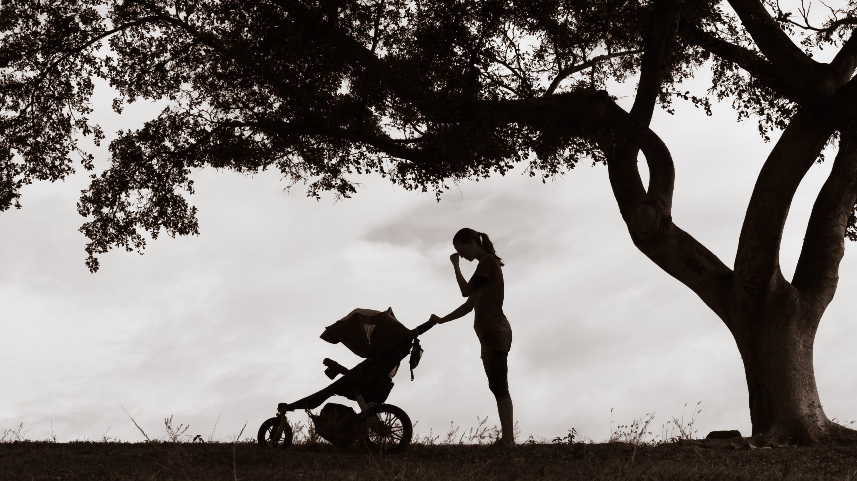 mother with postpartum depression pushing a stroller outside