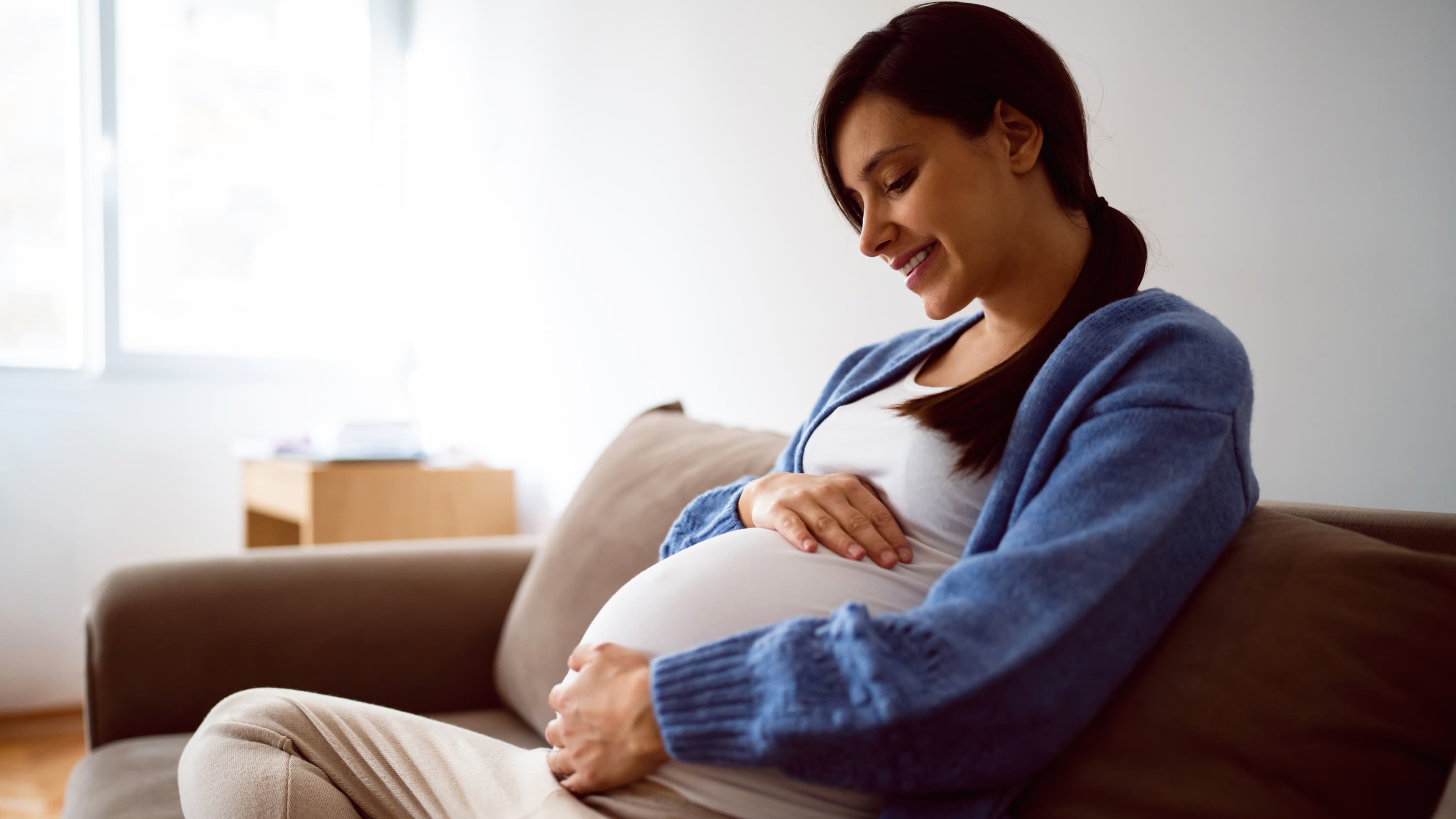 woman pregnant via IVF on couch 