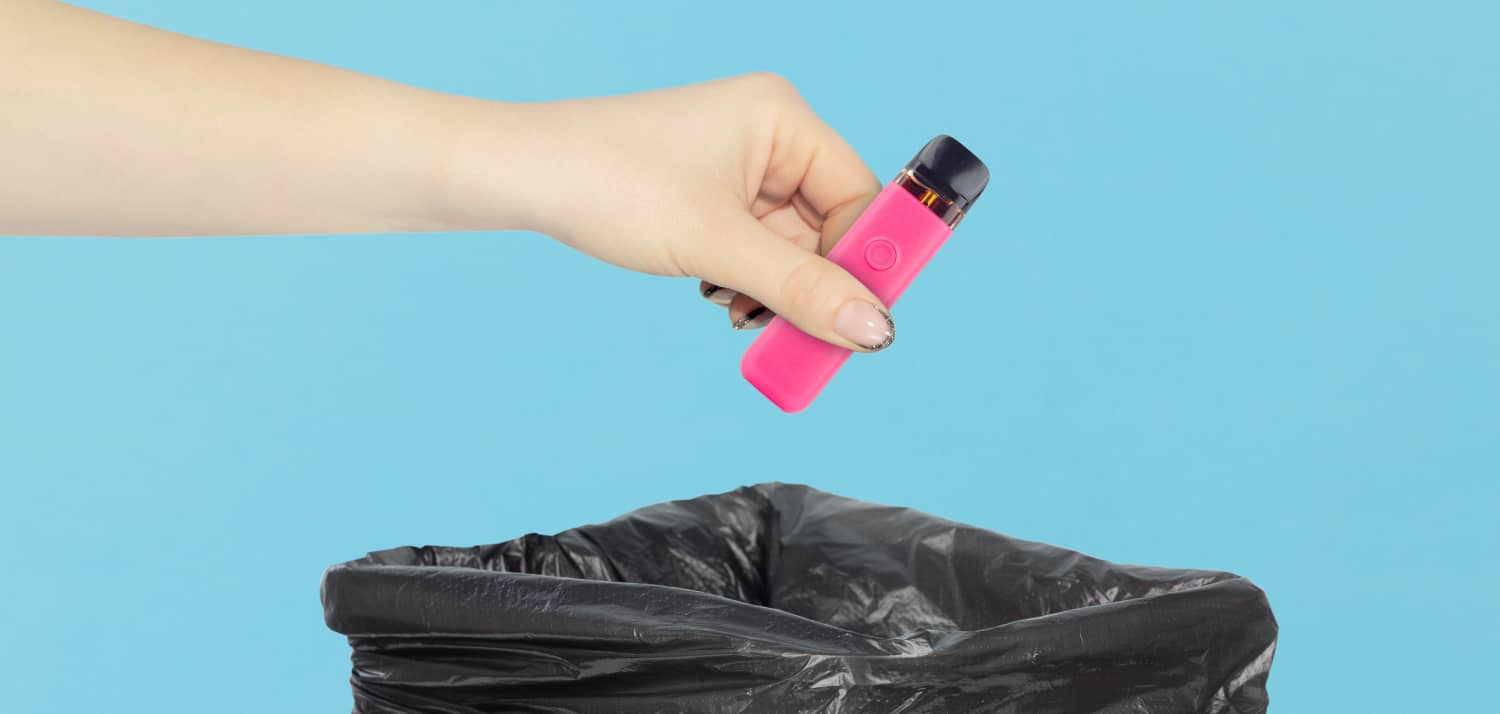 Person dropping an e-cig into a trashcan
