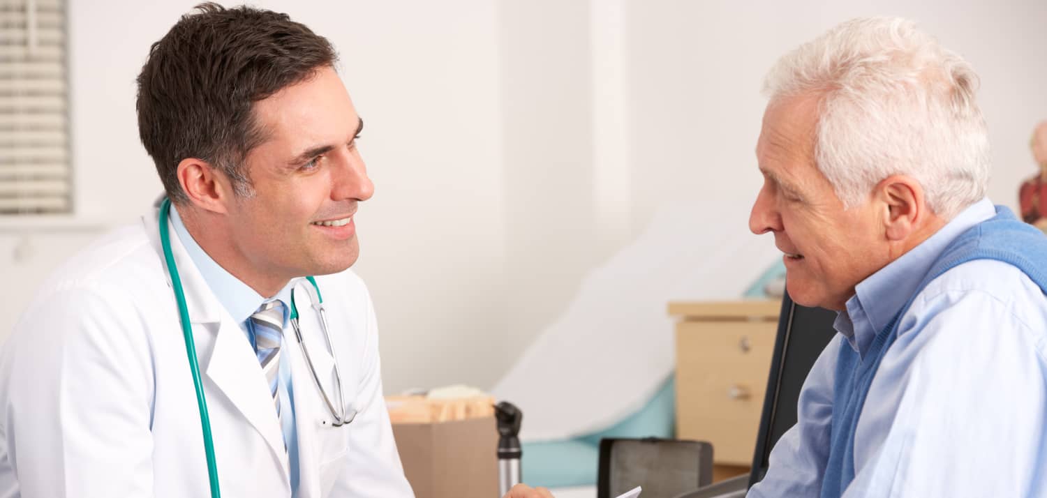 Male Doctor Speaks with Older Male Patient