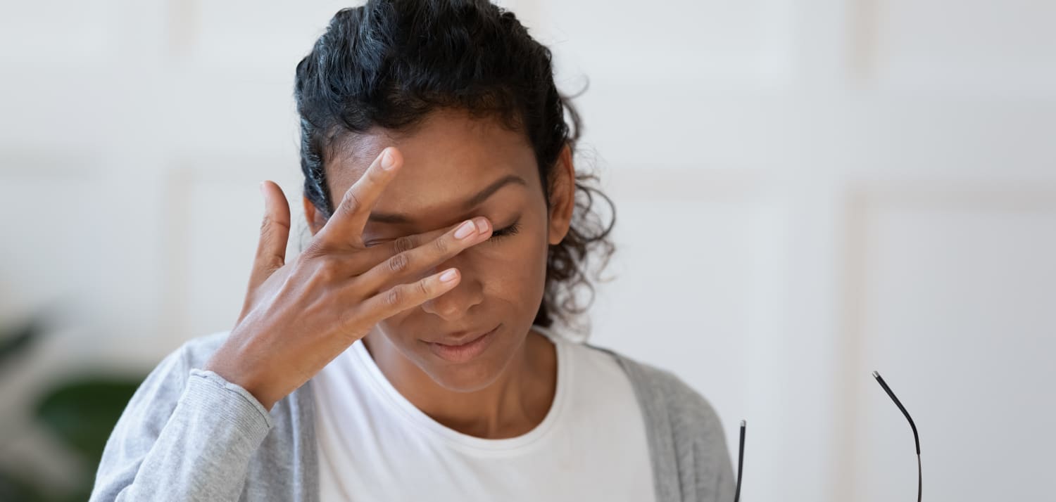 A woman with chronic dry eye takes rubs her eyes for relief