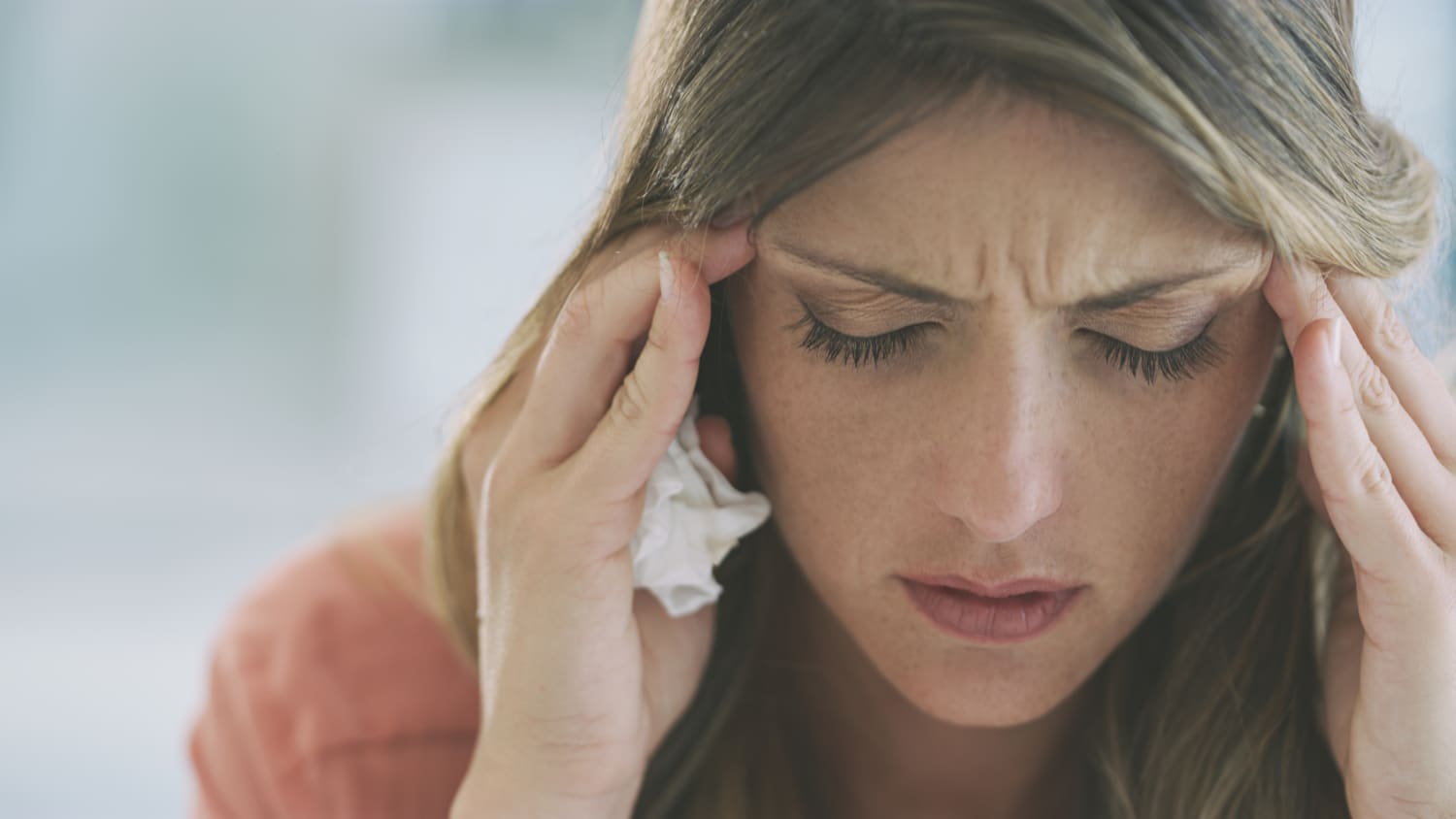 woman with headache, suffering from Paxlovid rebound, or COVID rebound