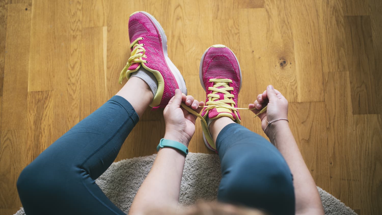 woman lacing up for a run before doing mobility exercises