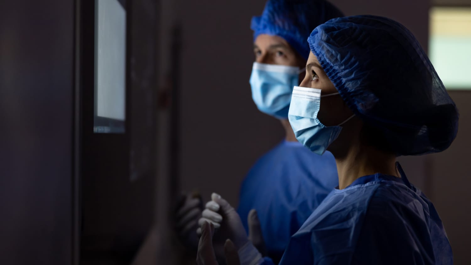 microsurgeons looking at a computer