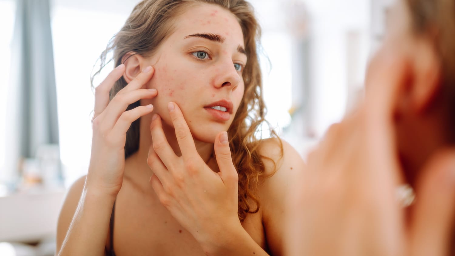 Woman Looks in Mirror