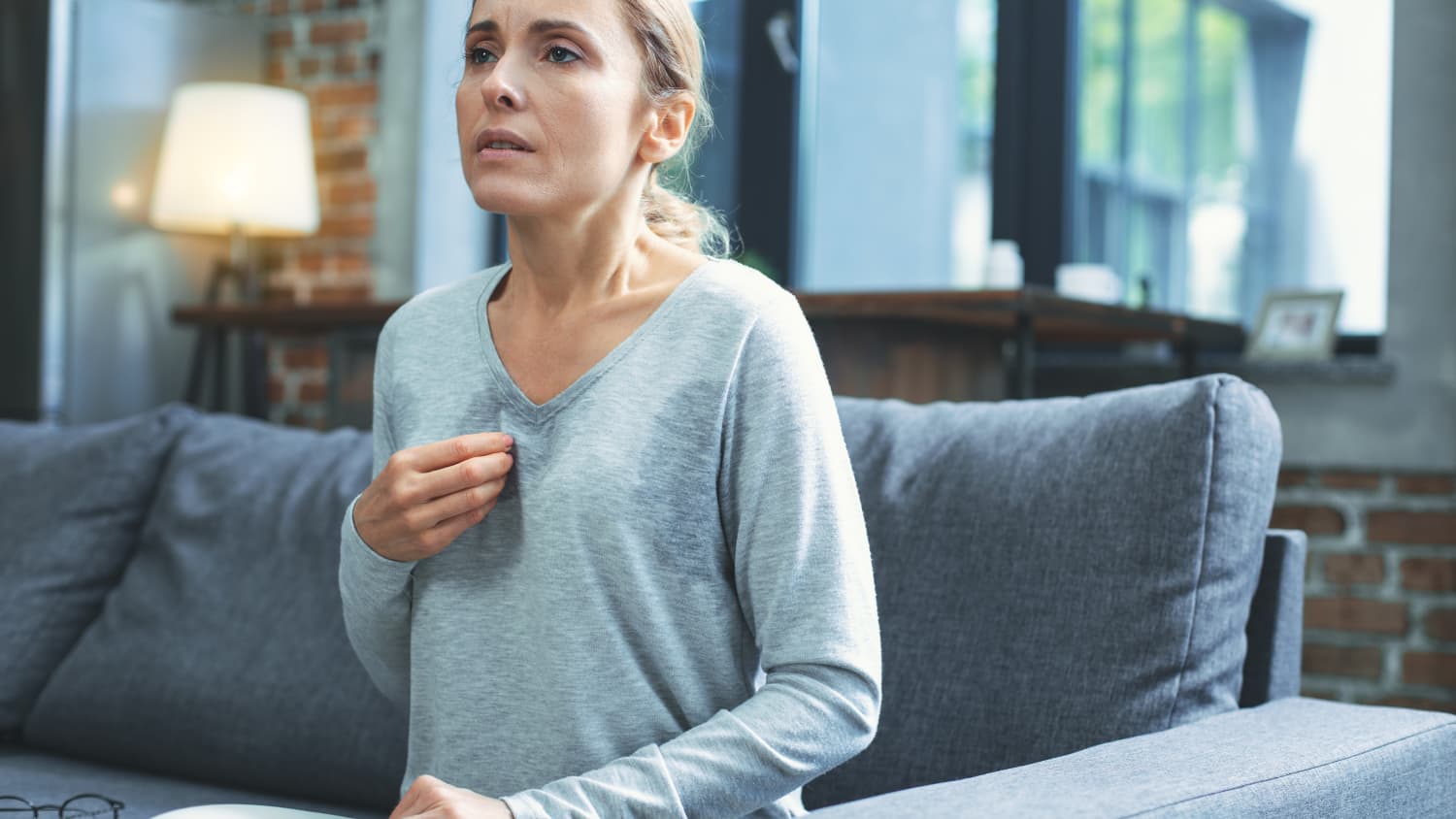 woman on couch experiencing a hot flash