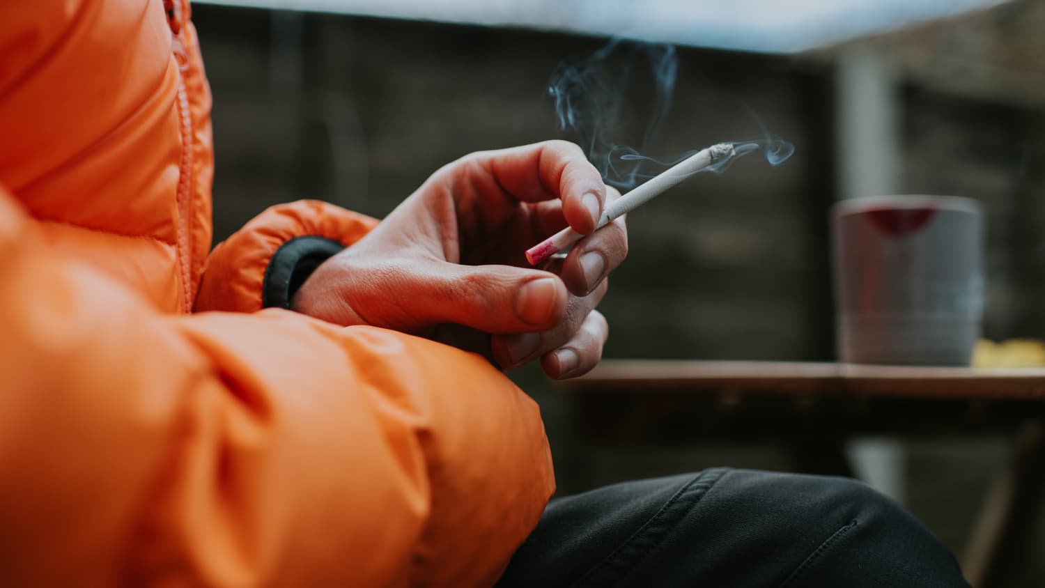 man holding cigarette representing dangers of thirdhand smoke