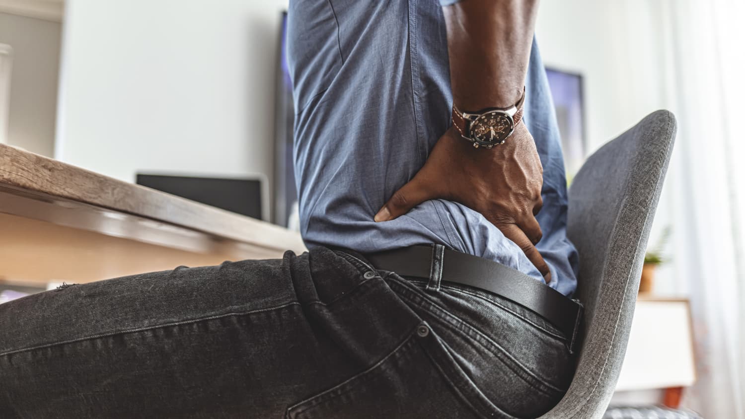 Man with pain from kidney stones, touching his lower back