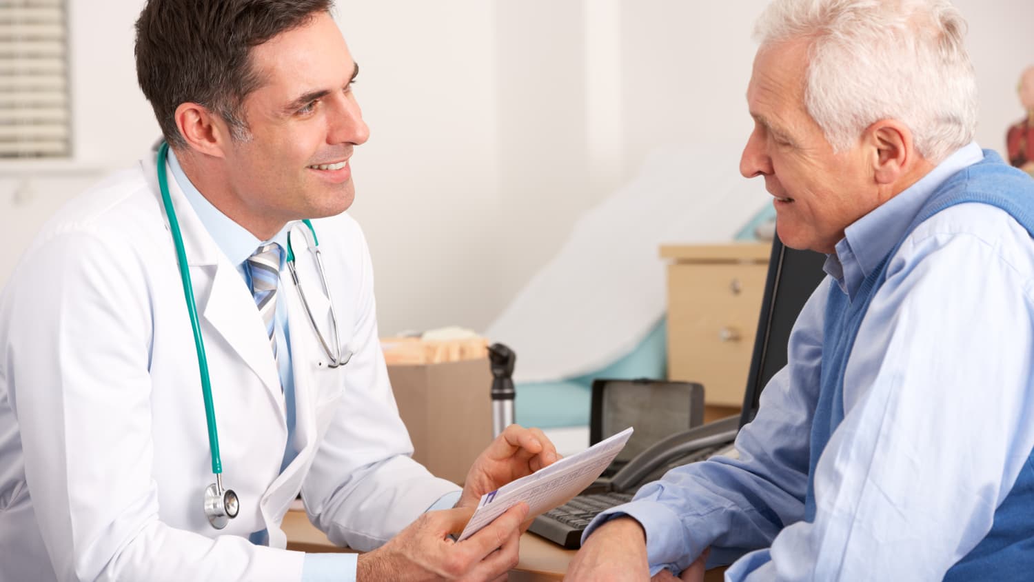 Male Doctor Speaks with Older Male Patient