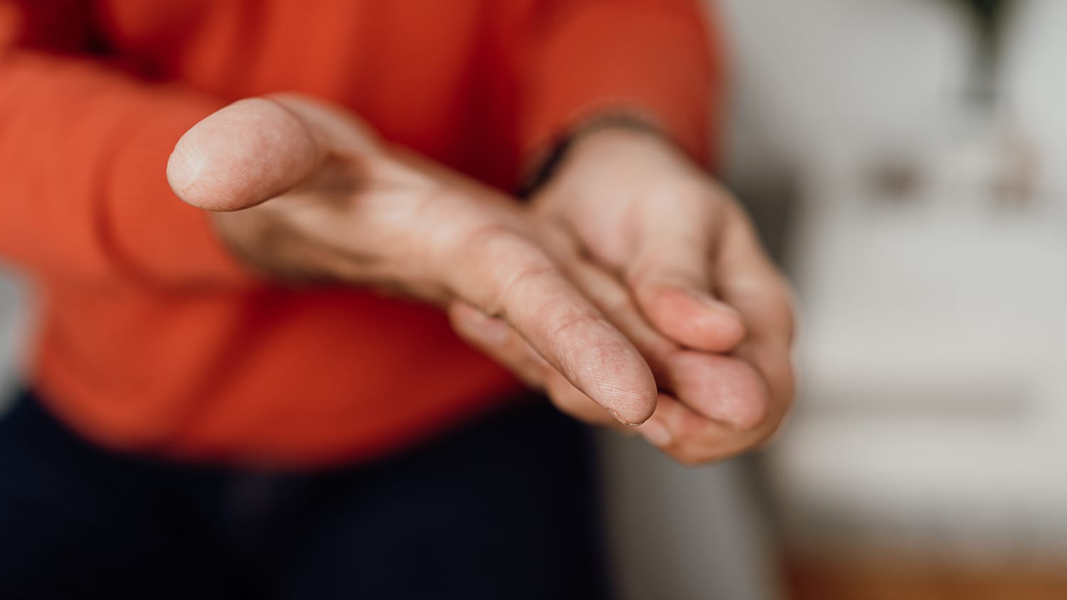 man massages his hand during a multiple sclerosis relapse