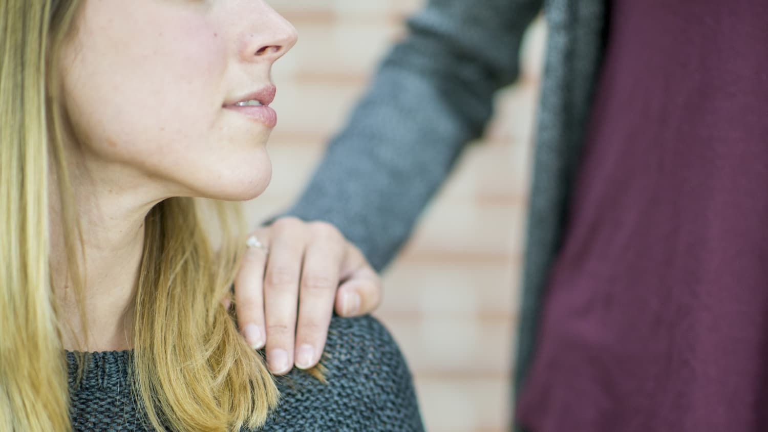 A person puts her and on the shoulder of a woman who may be experiencing a psychotic episode.