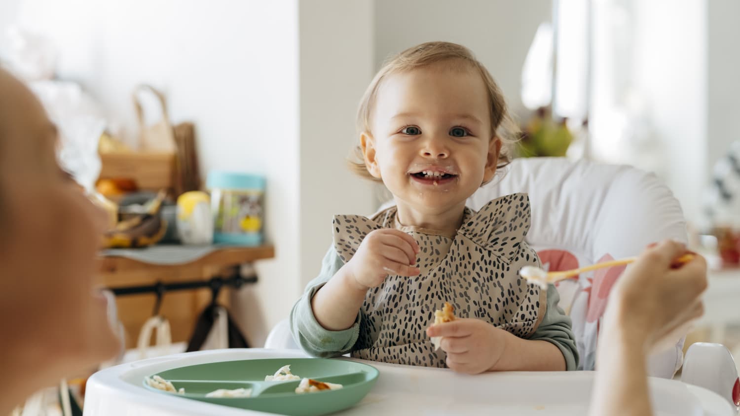 mother feeding her baby, attempting to avoid food allergies