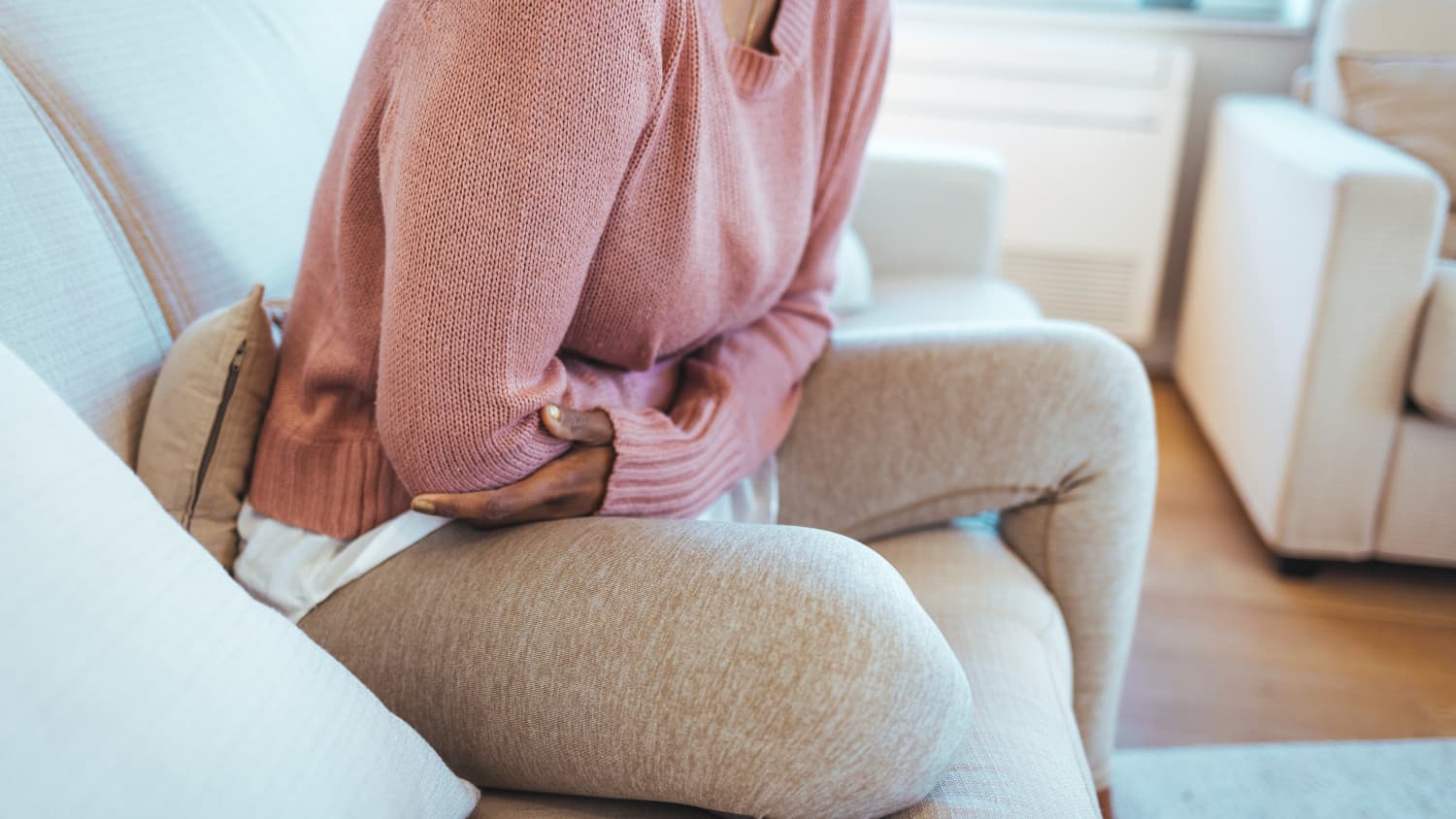 woman with pelvic pain from endometriosis on her couch
