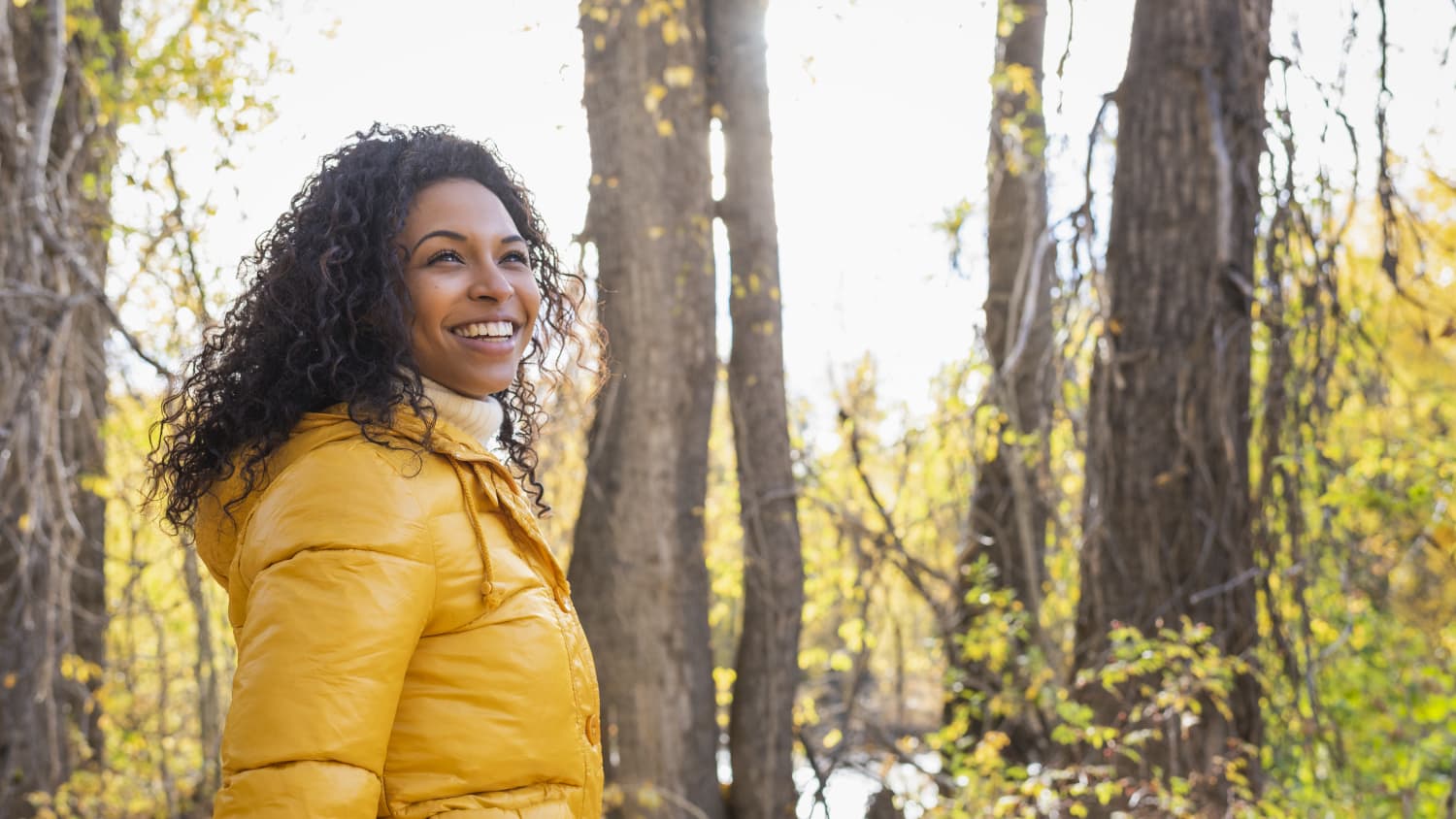 woman happy and walking in woods after transcranial magnetic stimulation (TMS) treatment